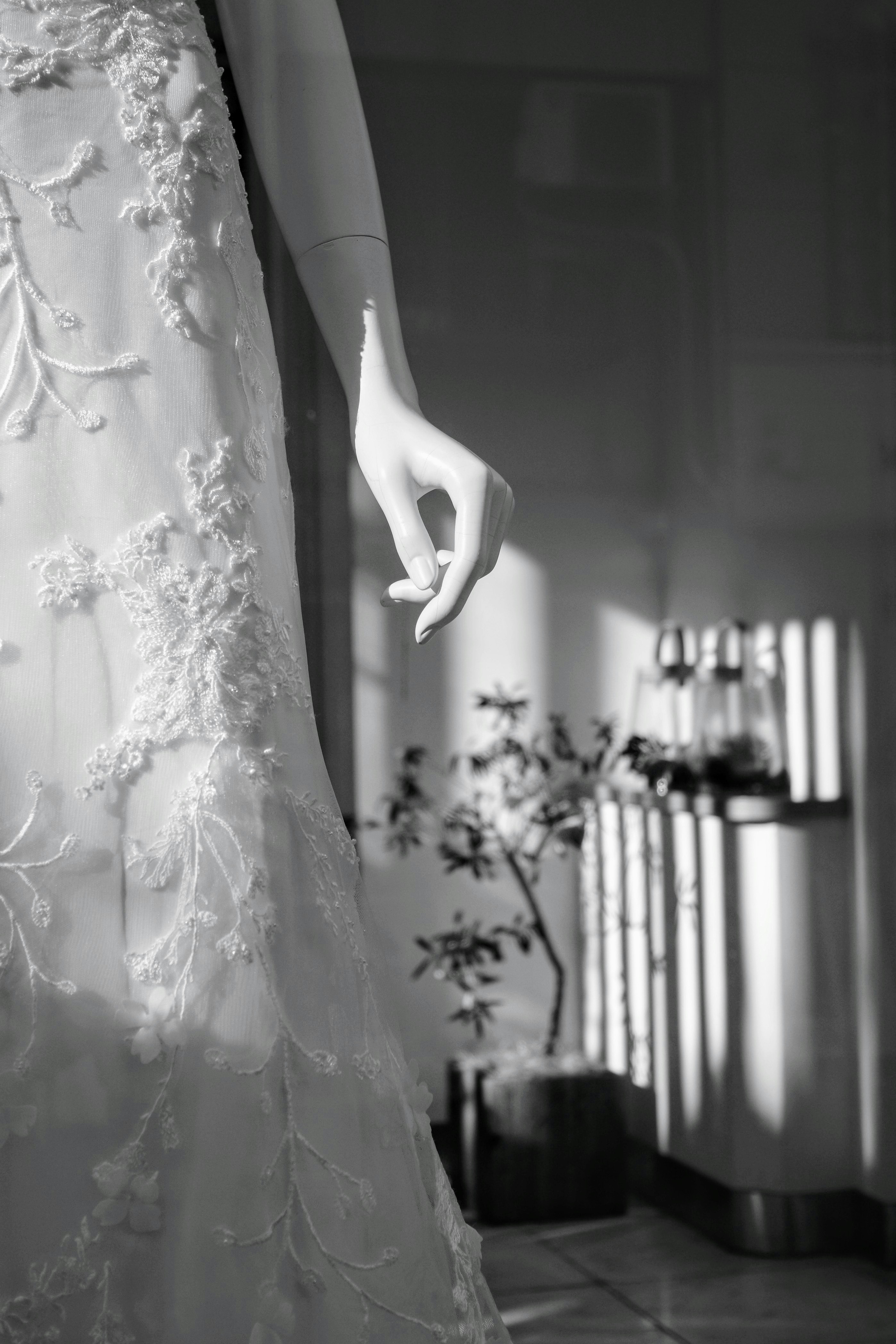 indoor aisle with lace dress hem and a hand reaching into frame