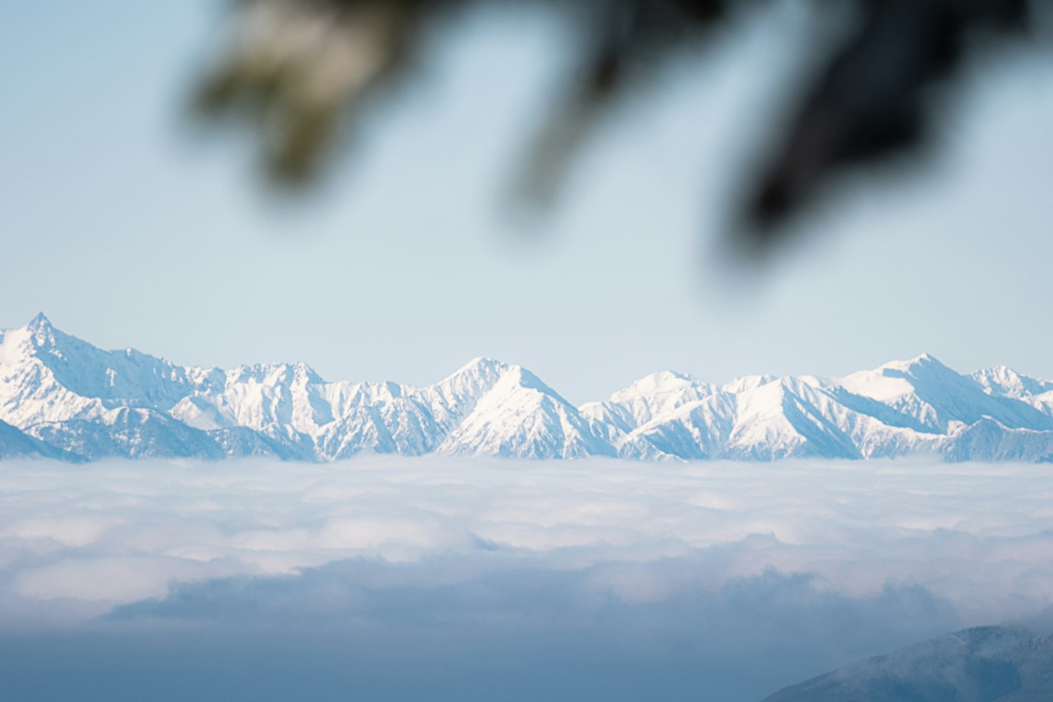 Montagnes enneigées surplombant une mer de nuages