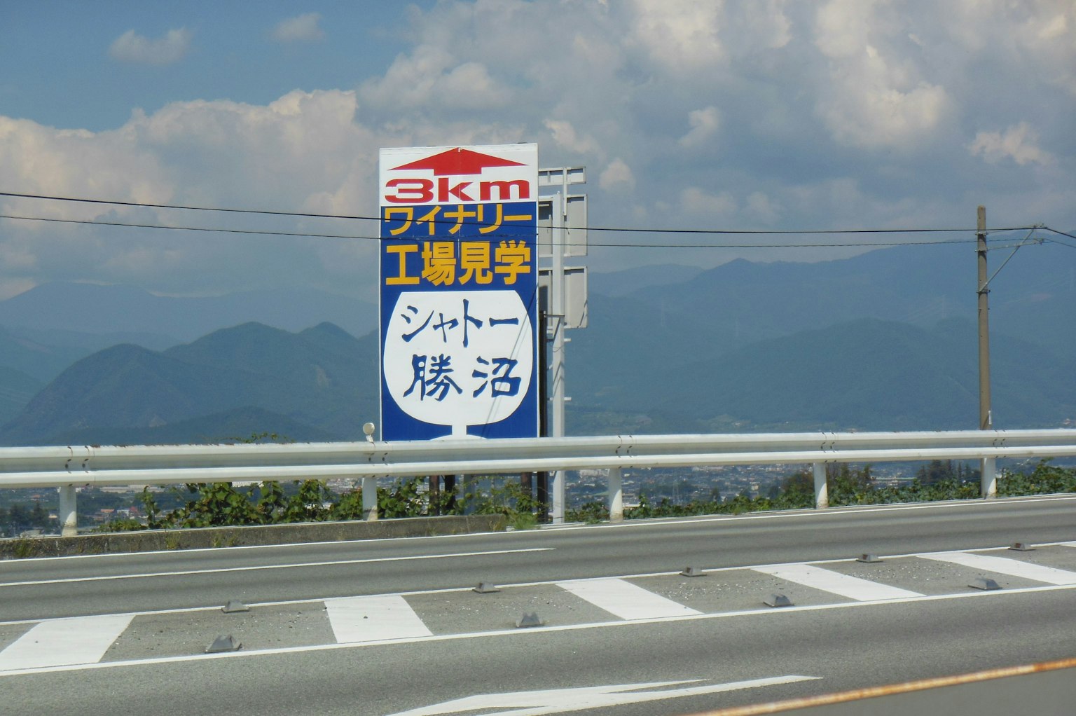 一块蓝色标志显示温泉信息，背景是山脉