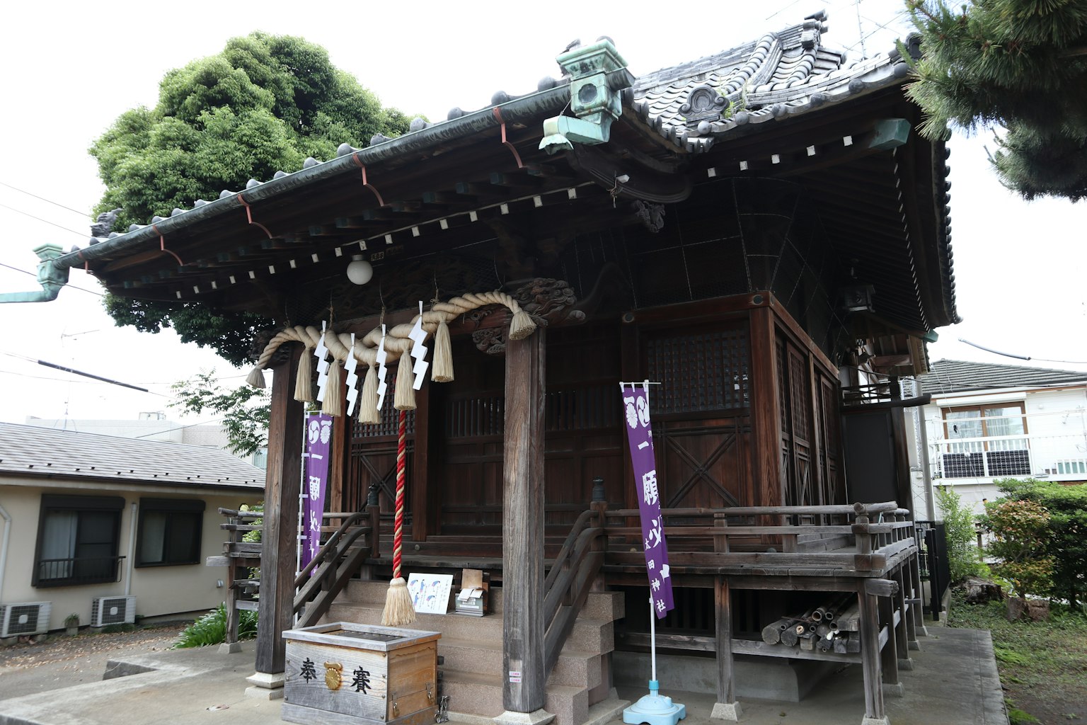 Traditionelles japanisches Schreingebäude umgeben von grünen Bäumen