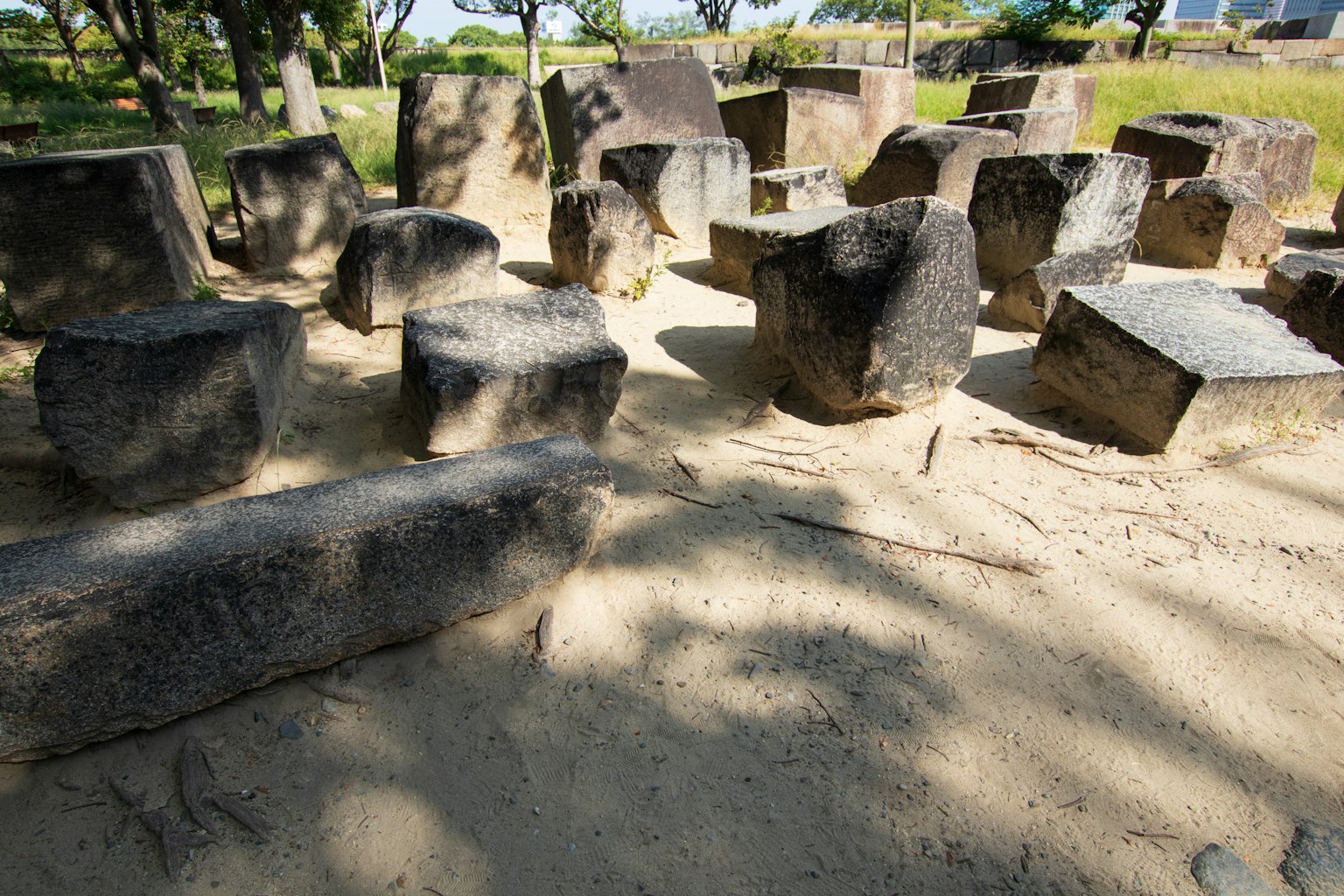 Stone structures arranged on sand with surrounding trees