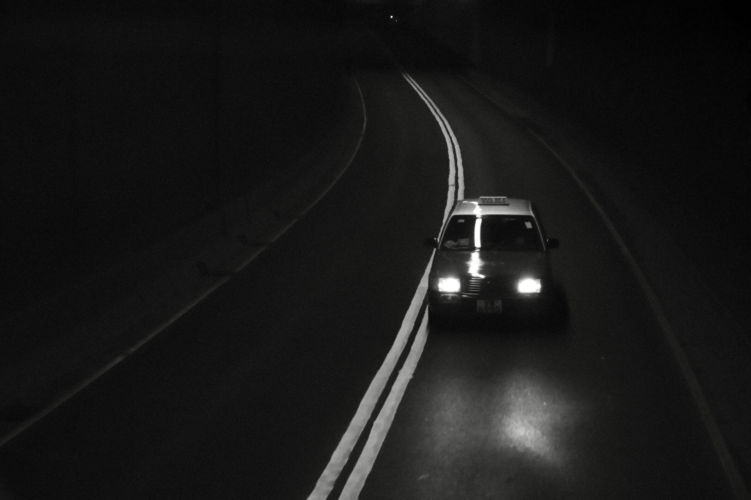 夜の高速道路を走る車のヘッドライト