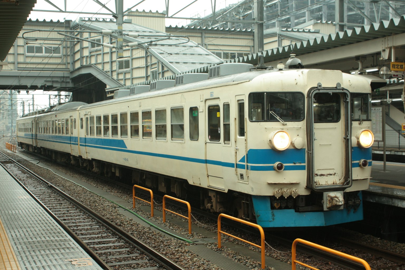 รถไฟที่มีลายสีน้ำเงินจอดอยู่ที่ชานชาลาสถานี