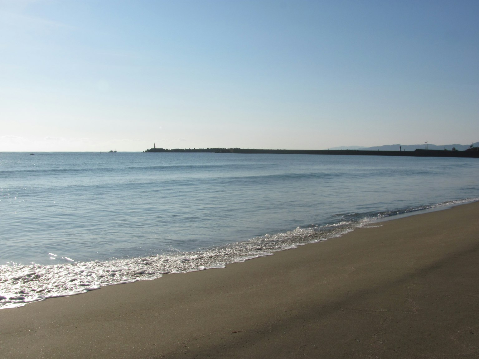 宁静的海滩场景，温柔的波浪和晴朗的蓝天