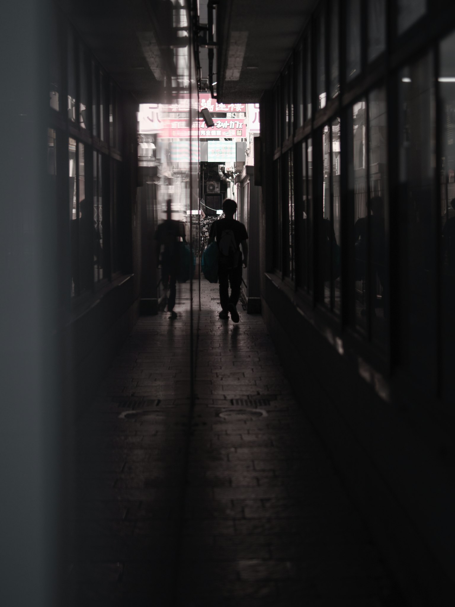 Silhouetten von Personen in einem schwach beleuchteten Flur