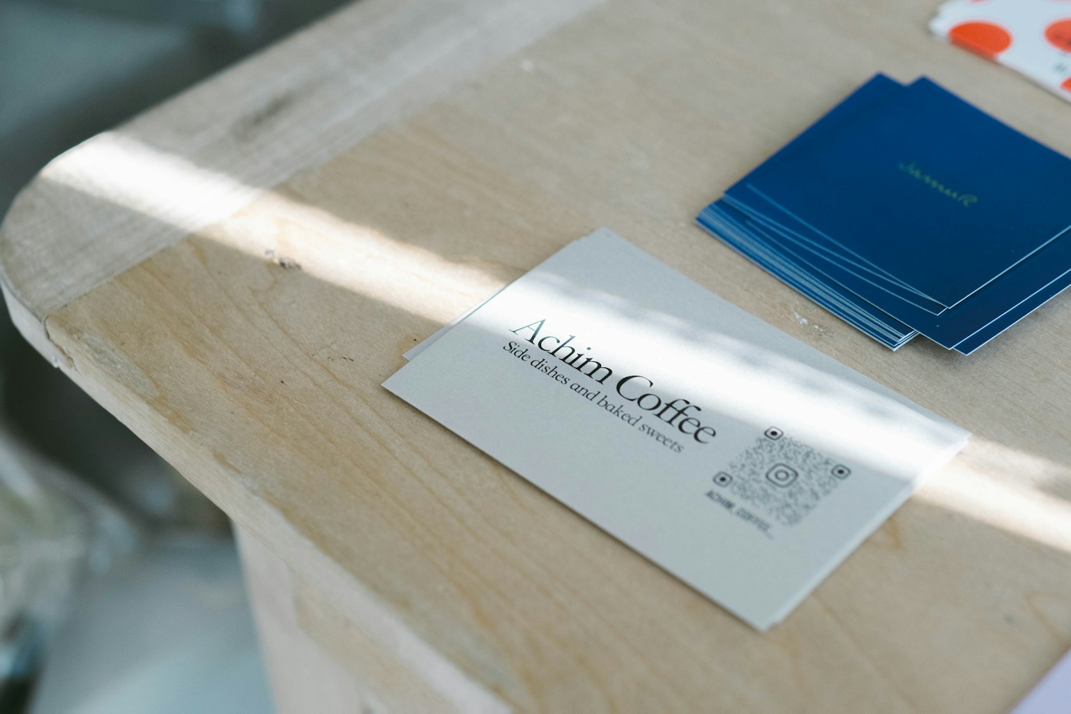 Tarjeta de presentación y tarjetas azules sobre una mesa de madera