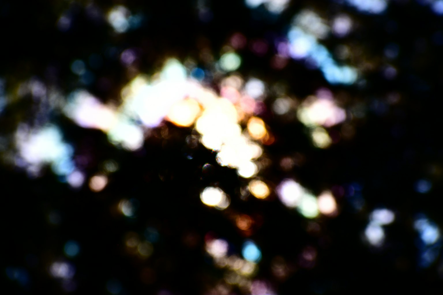 Abstract image with colorful light spots scattered against a black background