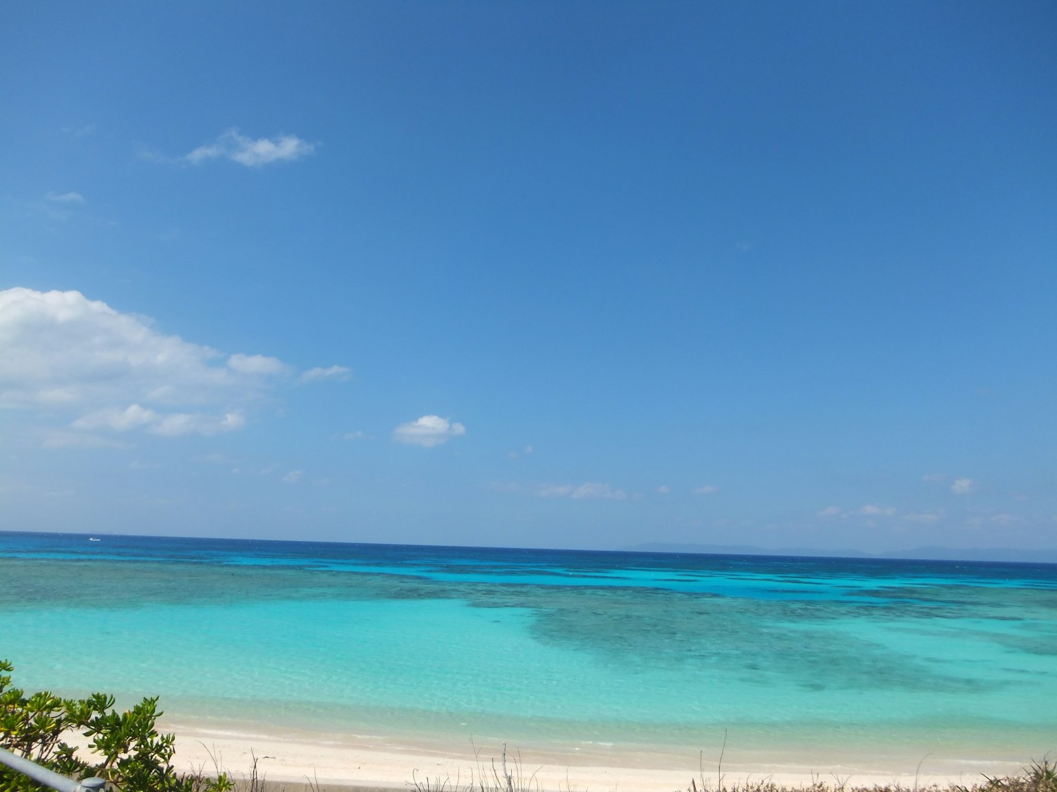 Vista panoramica di un cielo blu e mare verde smeraldo con una spiaggia di sabbia bianca