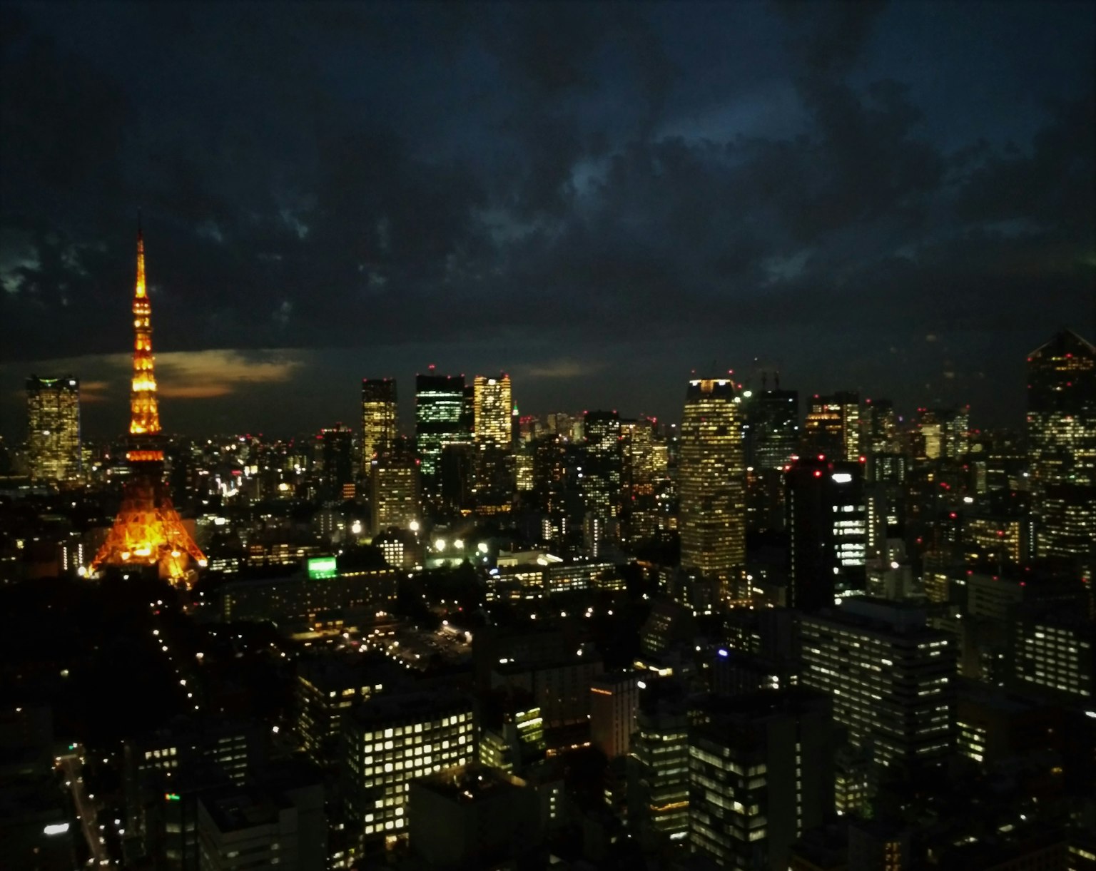 Torre di Tokyo illuminata contro lo skyline notturno di Tokyo con grattacieli