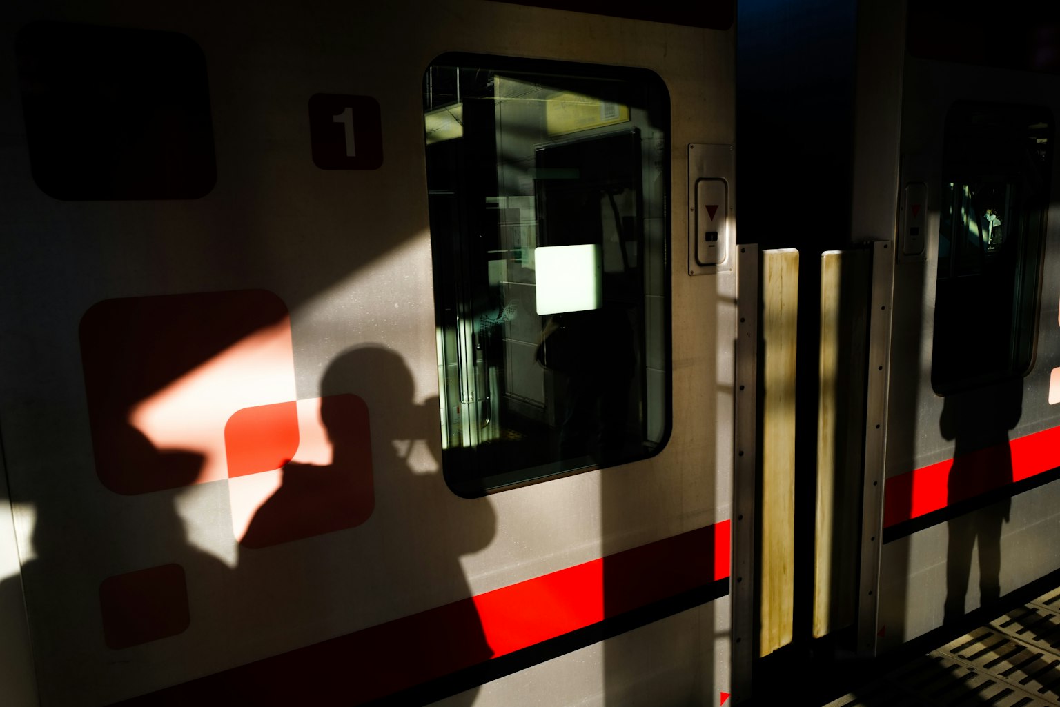 Un train à une station avec des ombres et de la lumière du soleil