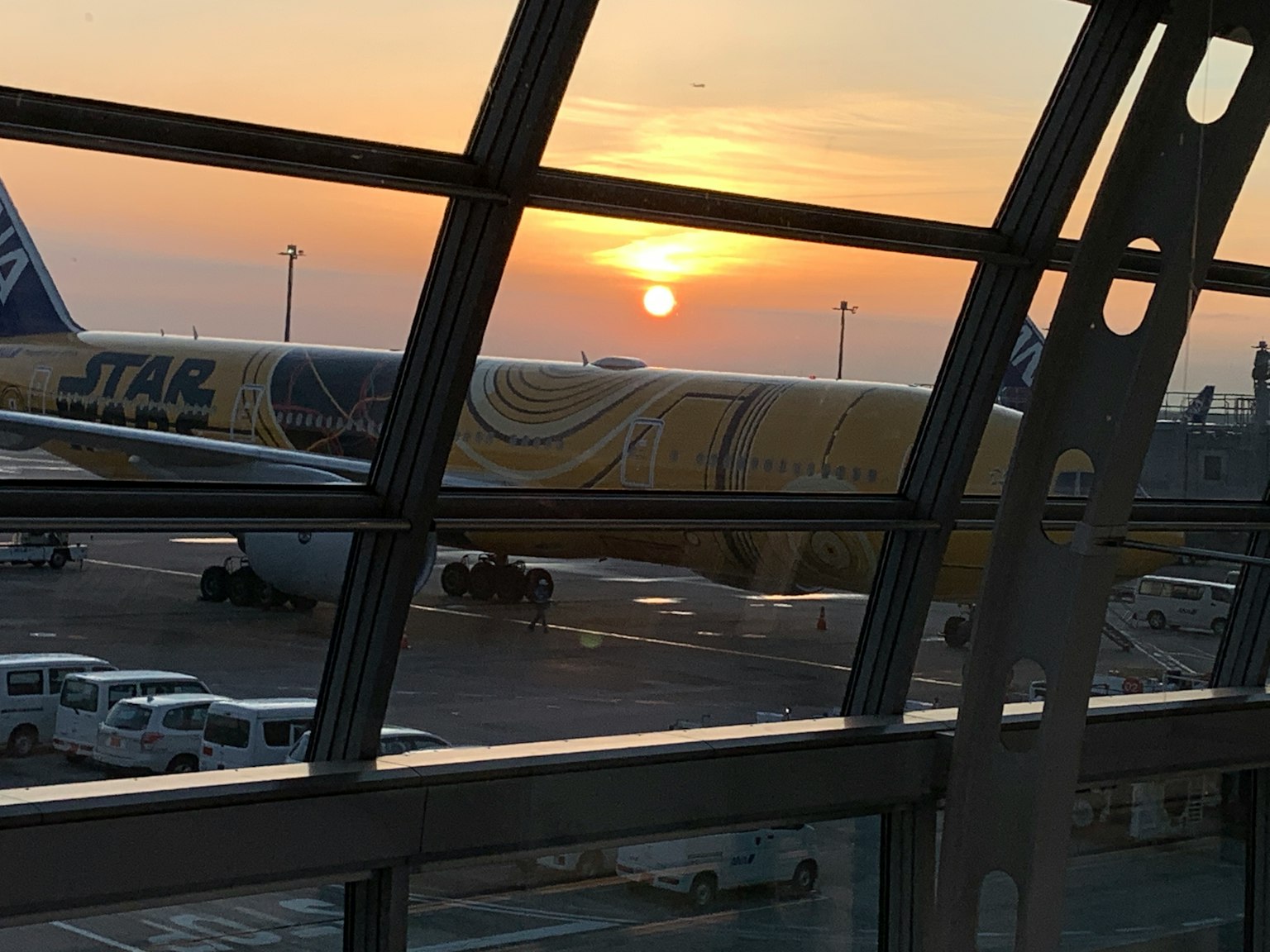 View of sunset and airplane from airport window
