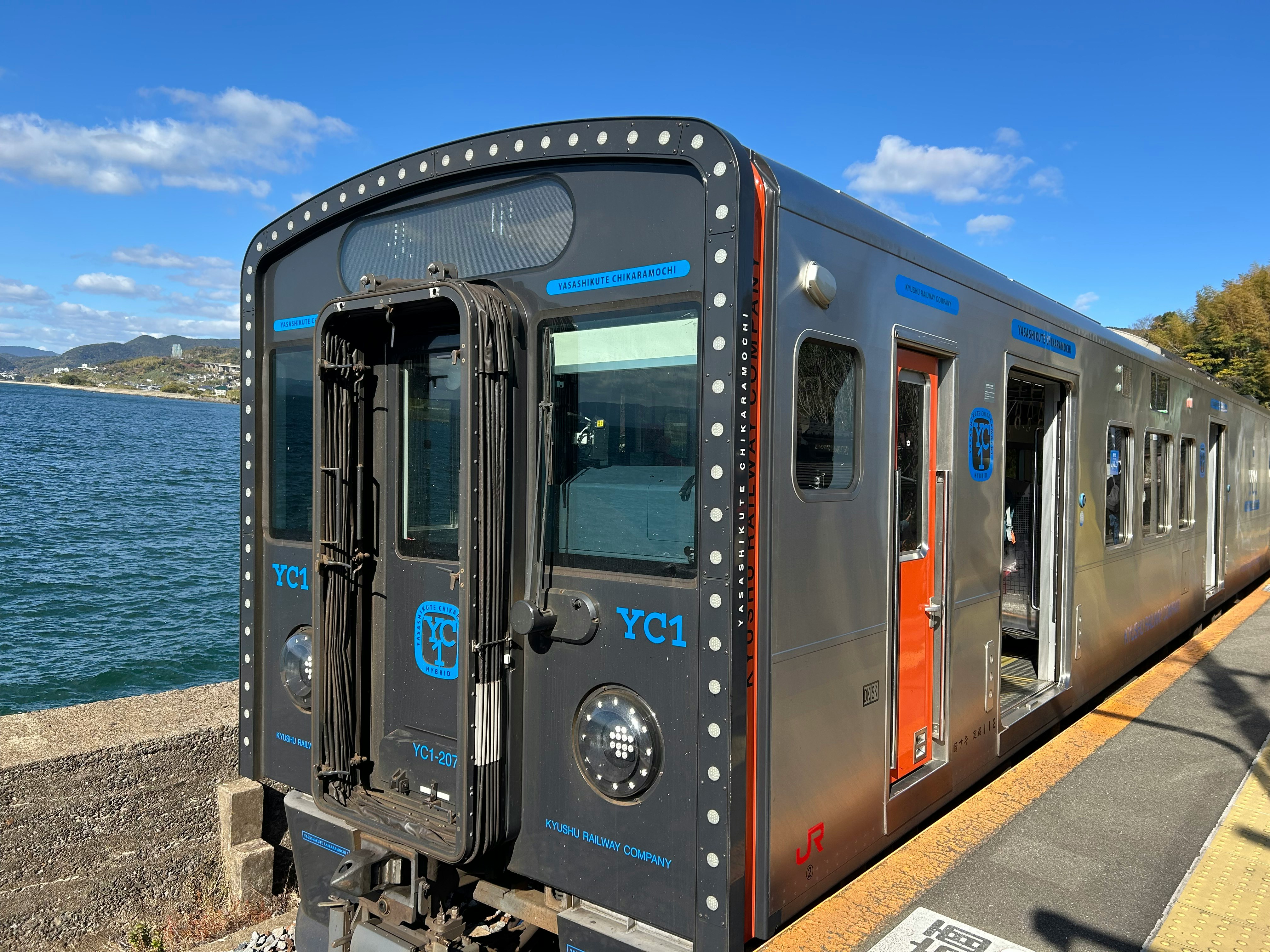 冬の海沿いの駅で停車する列車