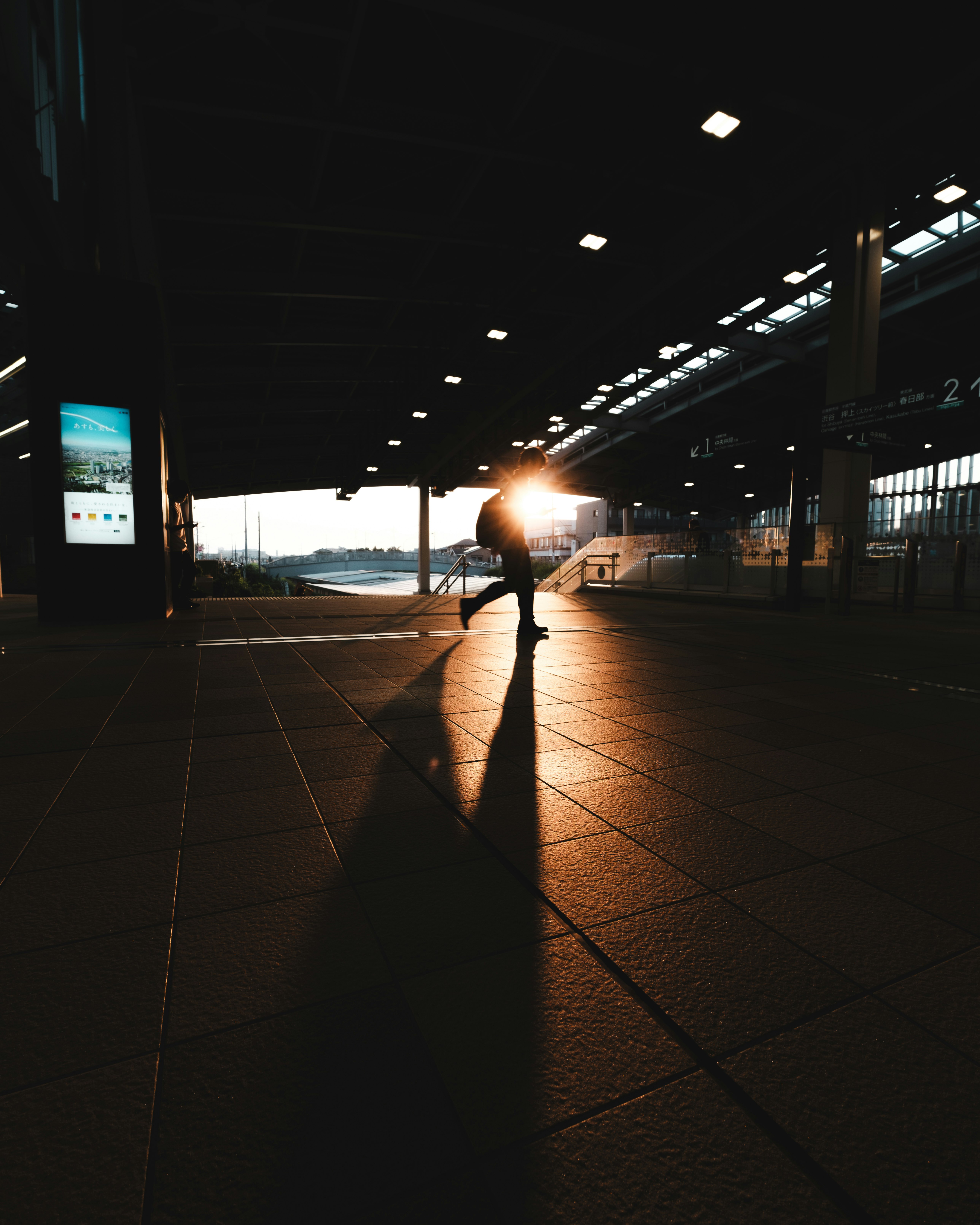 train platform walkway with a silhouetted figure in sunset light