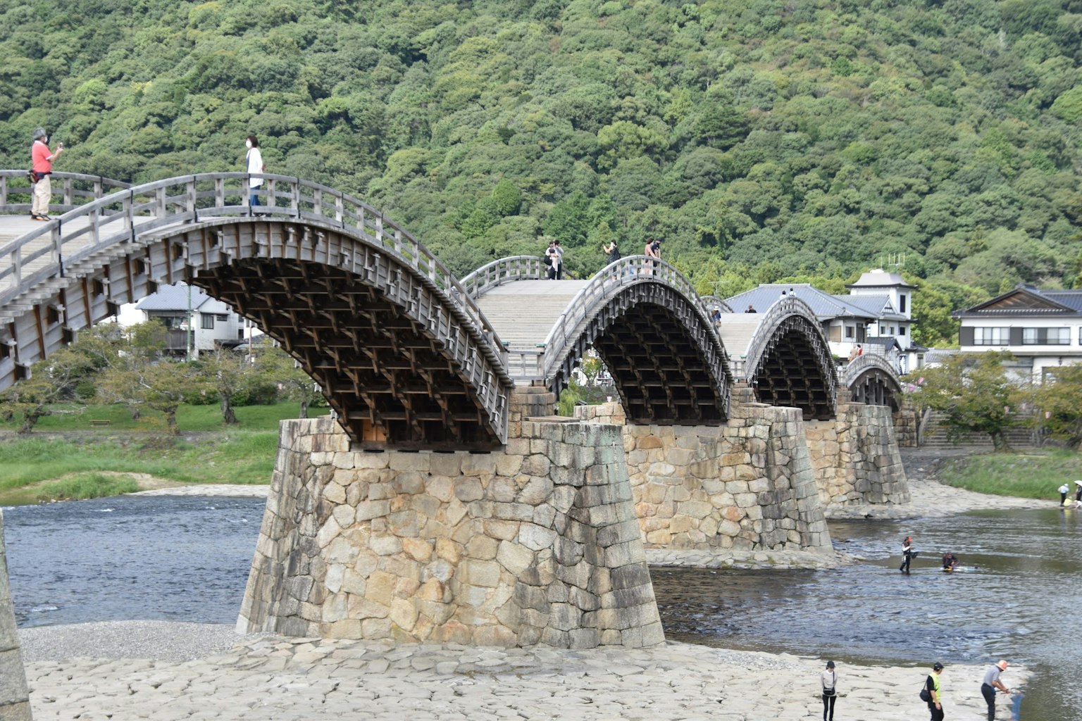 Vue pittoresque d'un beau pont en bois en arc soutenu par des piliers en pierre