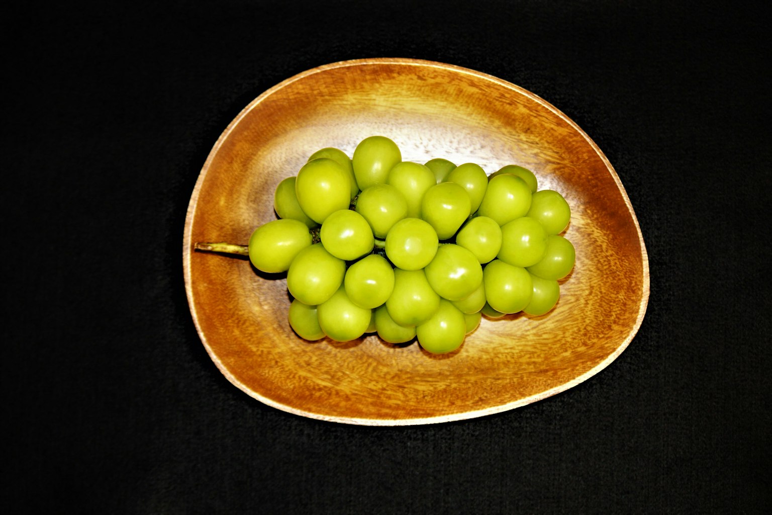 绿色葡萄放在棕色盘子上
