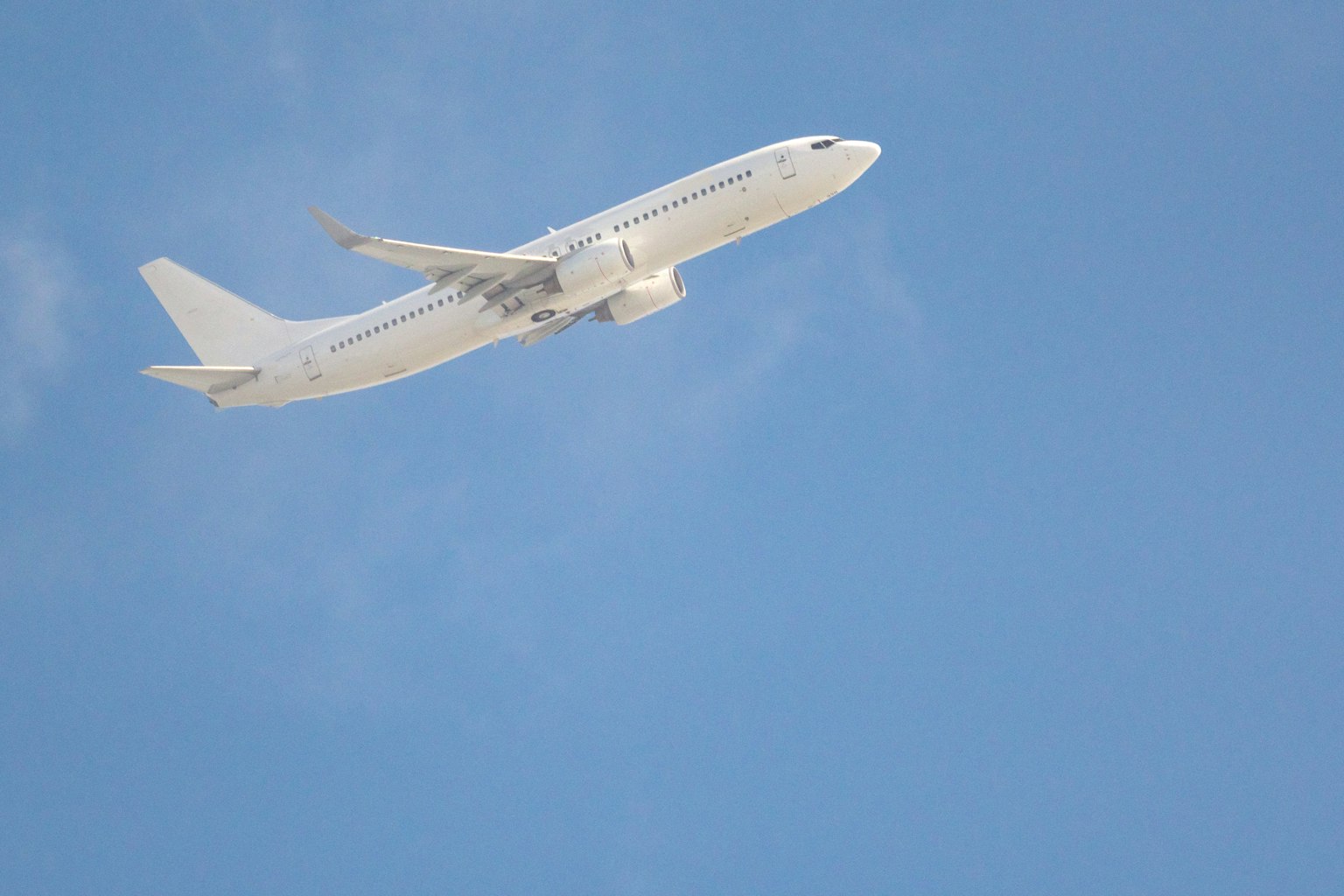 파란 하늘을 배경으로 나는 흰색 비행기