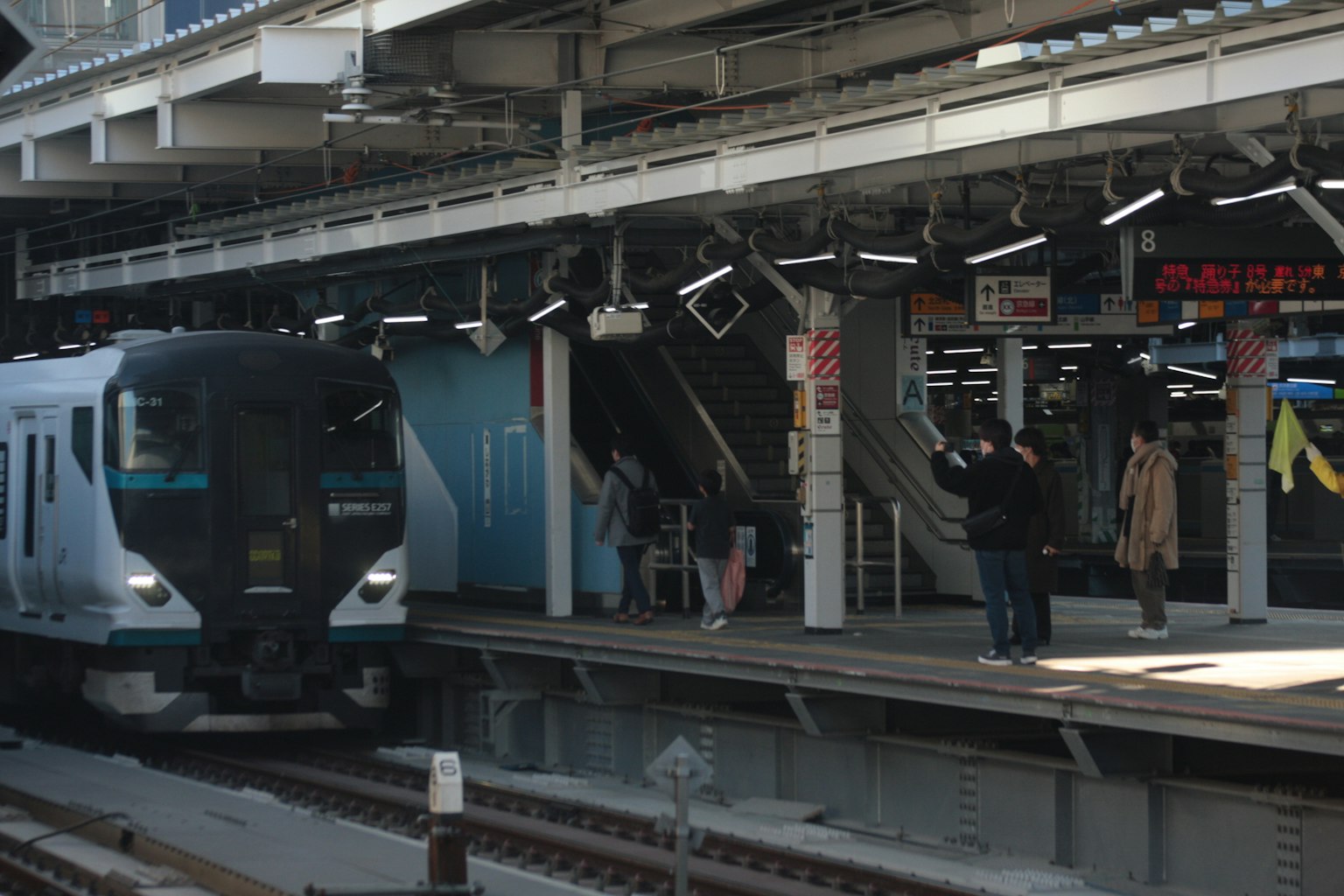ผู้คนรอที่สถานีรถไฟกับรถไฟที่เข้ามา