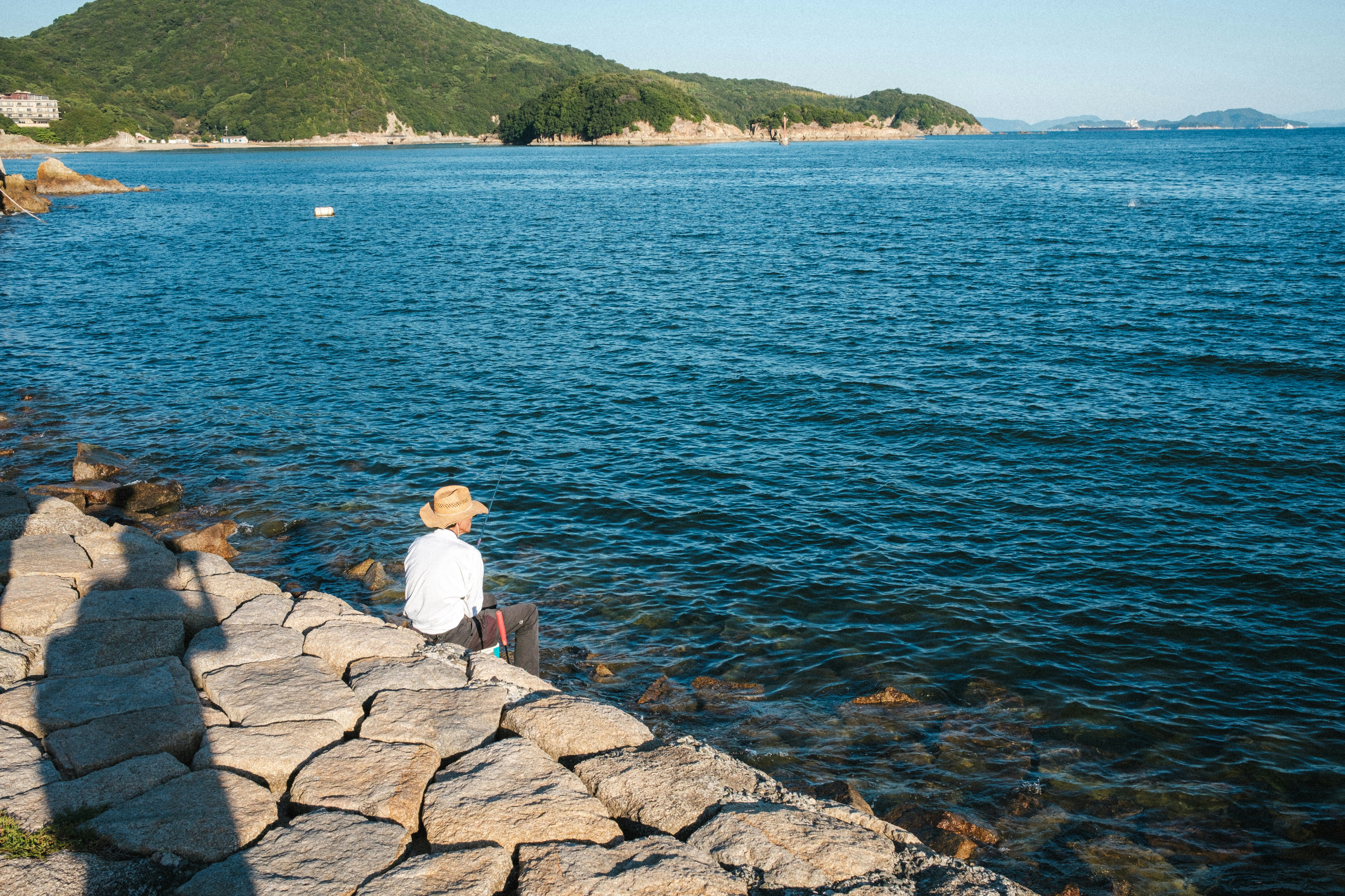 岩石海岸上釣魚的漁夫背影