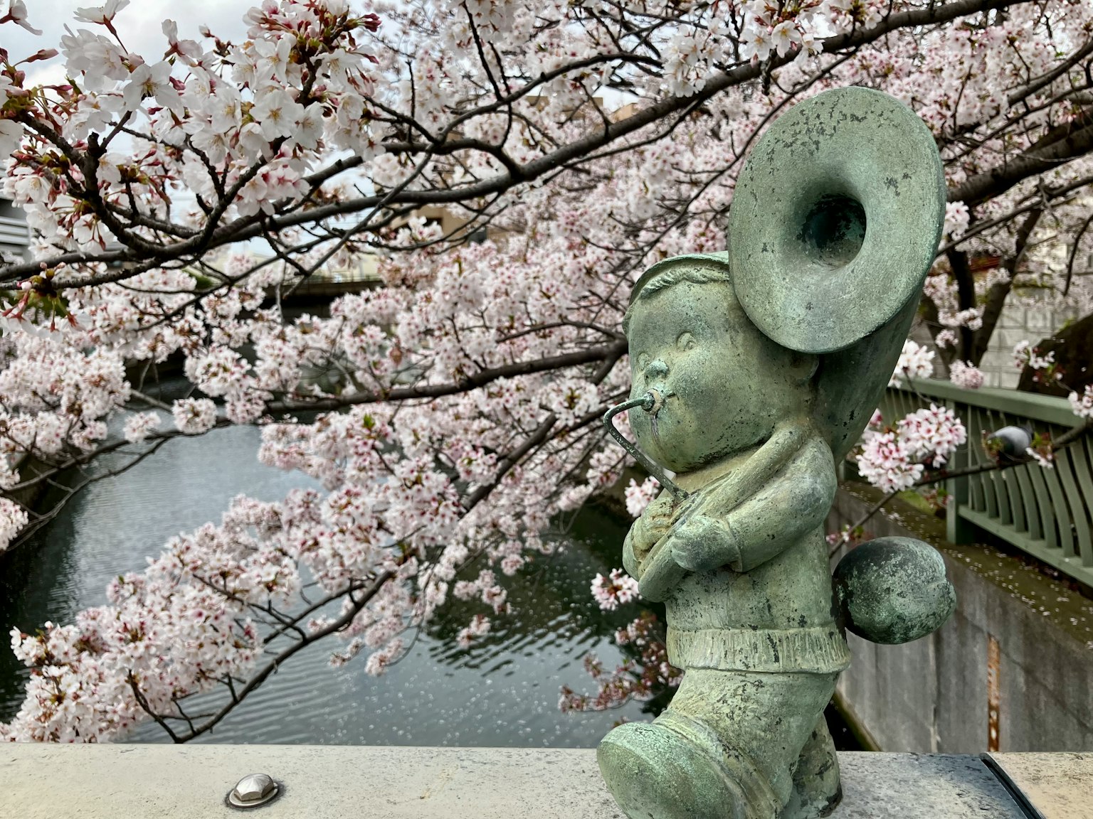 Bronzestatue eines Musikers vor einem Kirschbaum