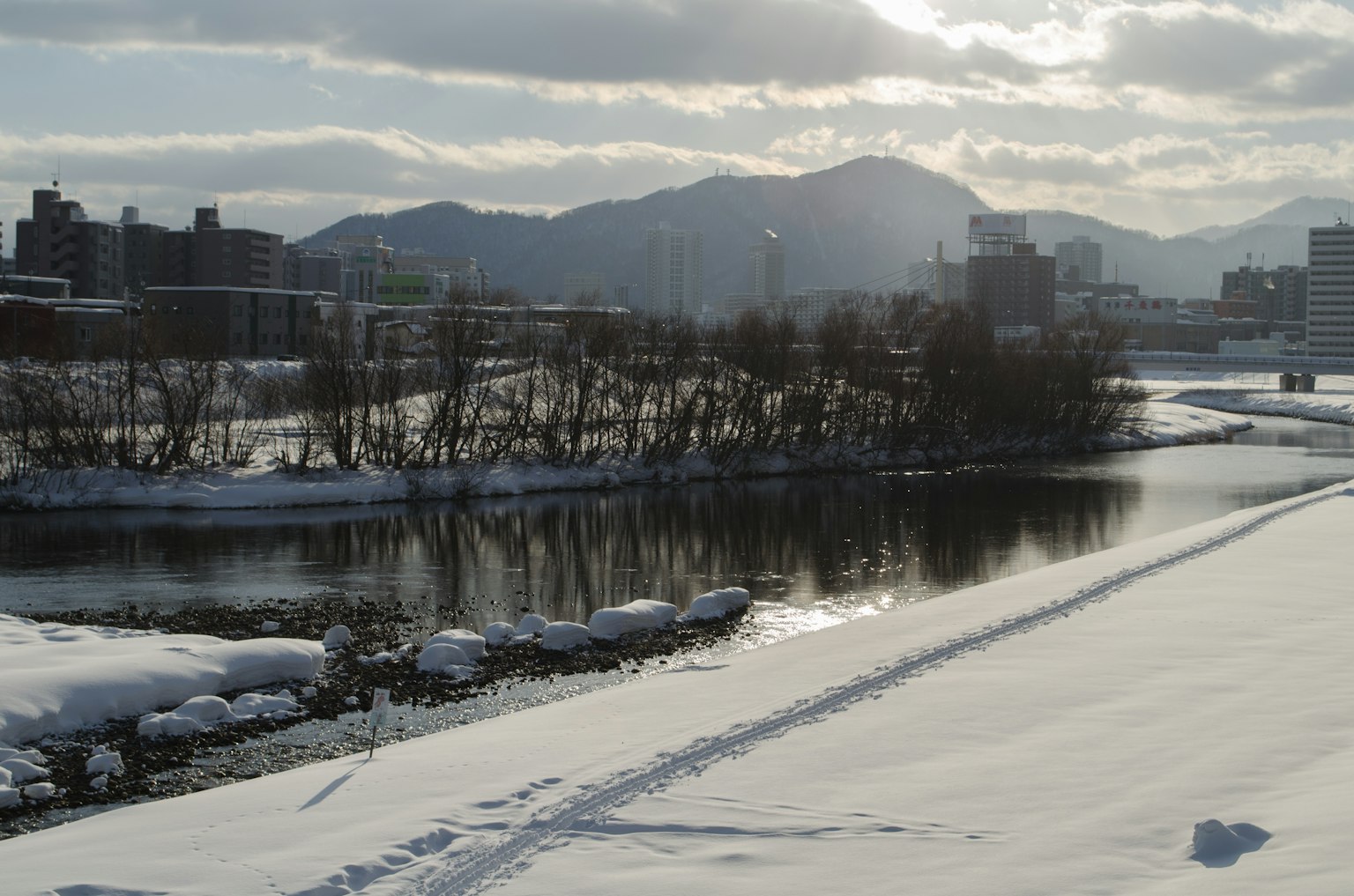 Snow-covered river landscape with mountains