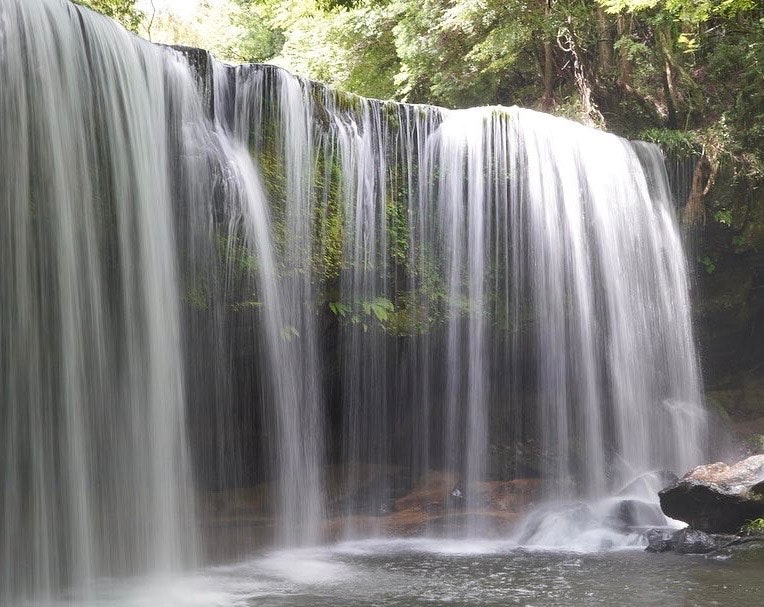 滝の流れと水しぶきが広がる自然の景観
