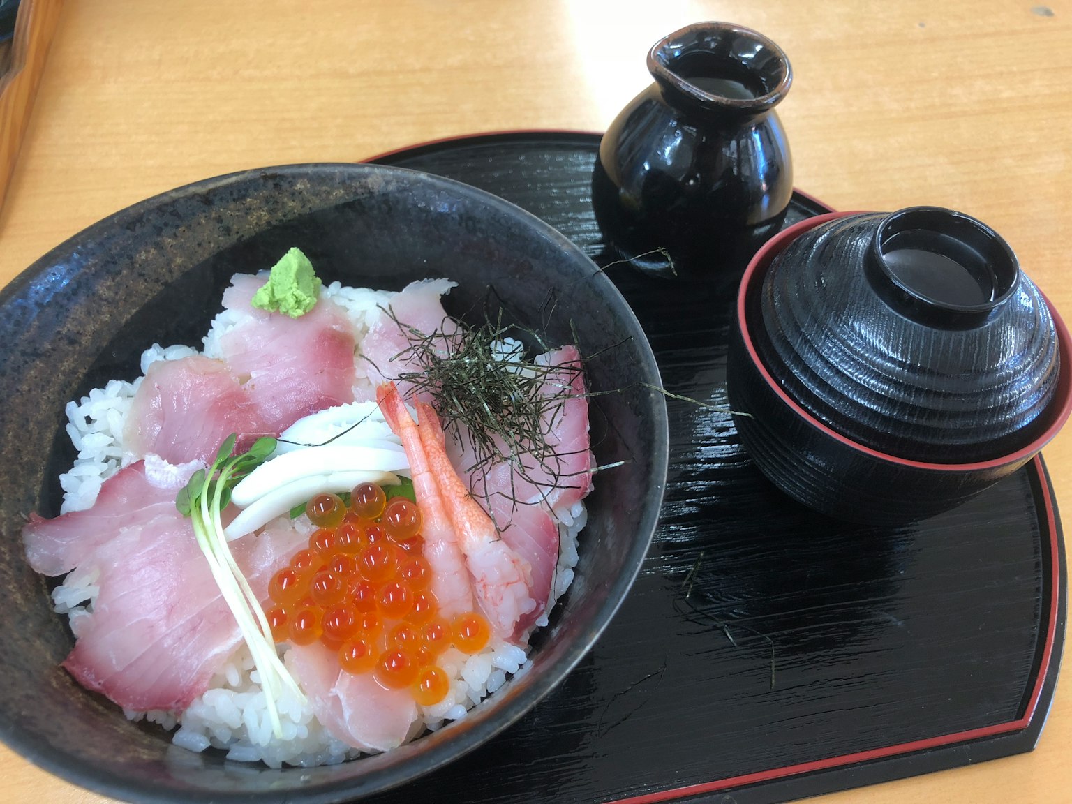 Tazón de arroz cubierto con sashimi fresco y huevas de salmón