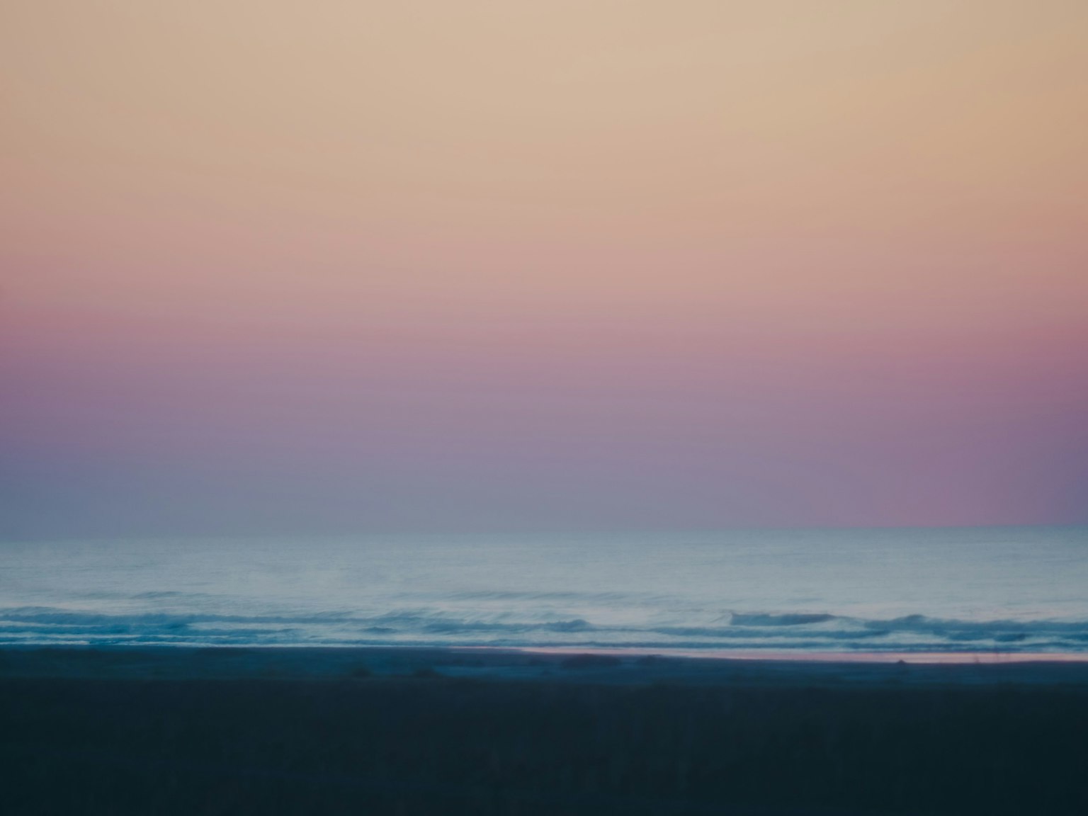 Laut tenang dengan warna langit pastel yang lembut