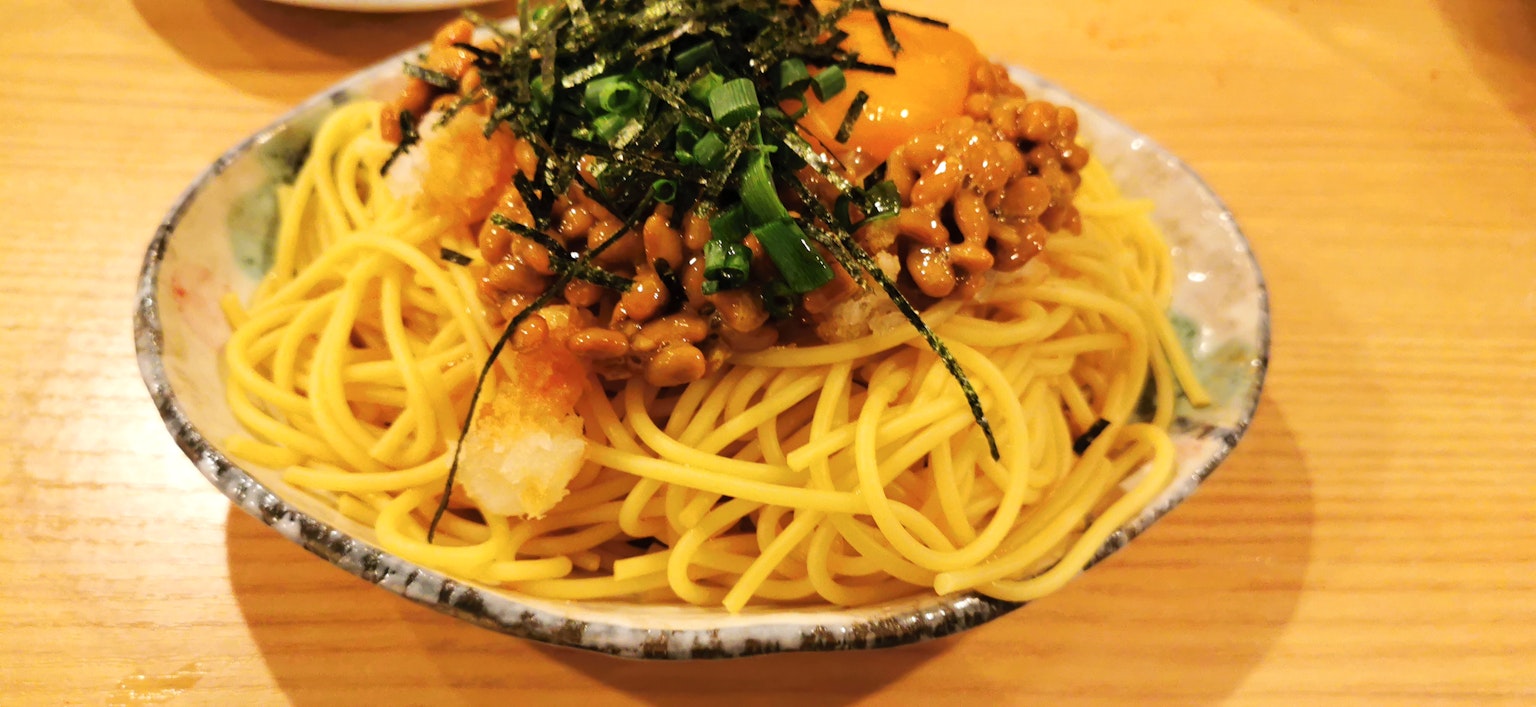 Đĩa spaghetti phủ natto, trứng và rau thơm