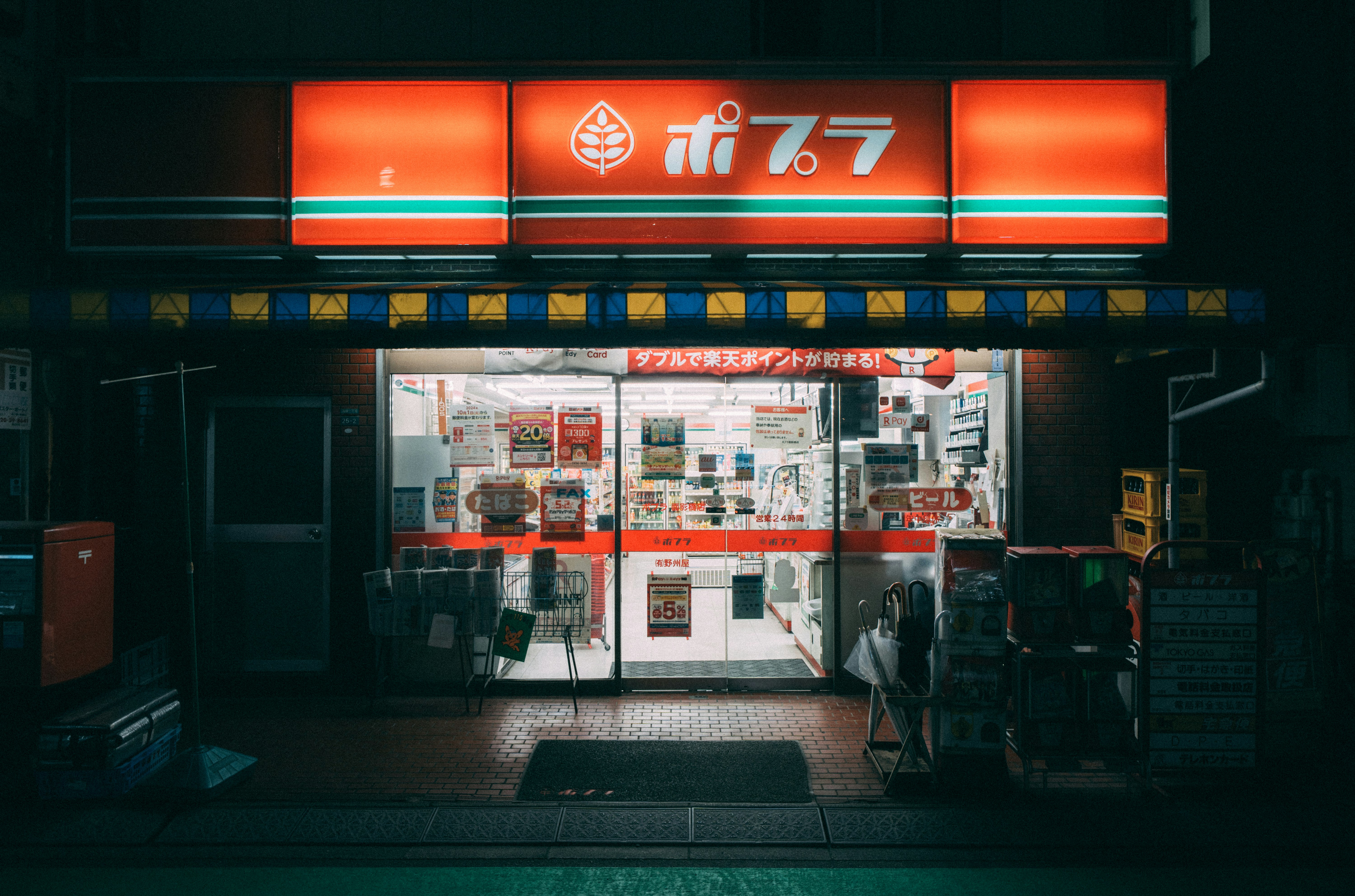 ネオンに照らされた店先の自動販売機と看板のある夜の通り