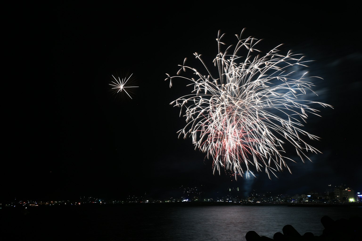 Feuerwerk, das den Nachthimmel über dem Wasser erleuchtet