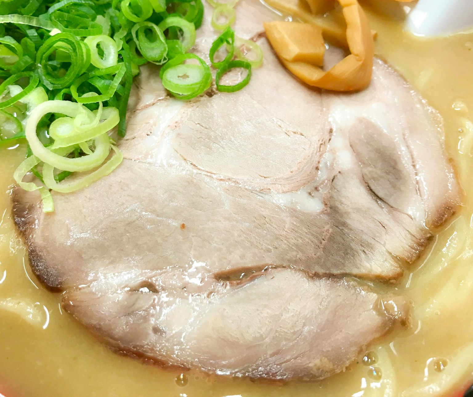 拉面上的叉烧肉片配青葱和竹笋
