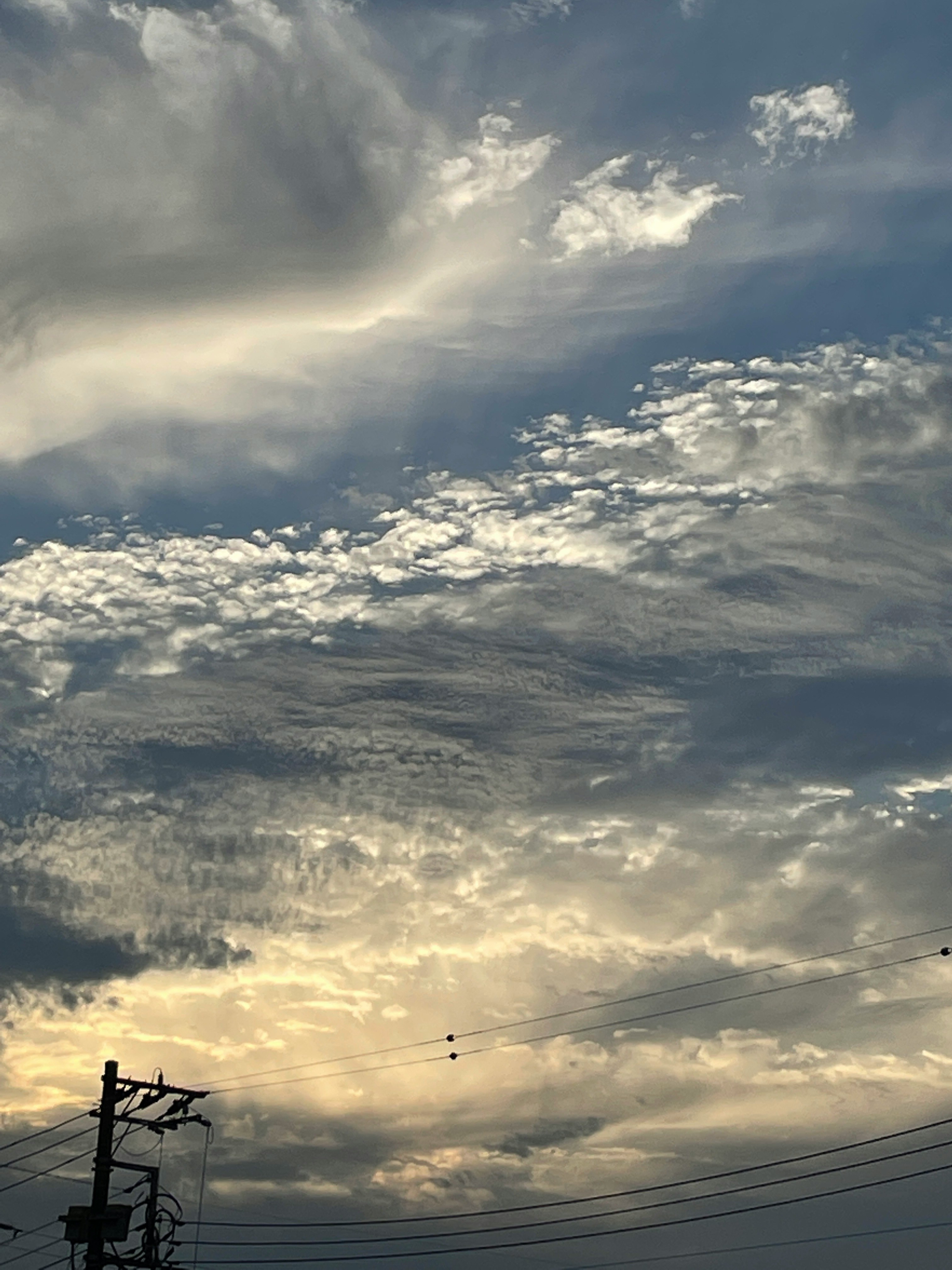 雲が広がる夕暮れの空と電線