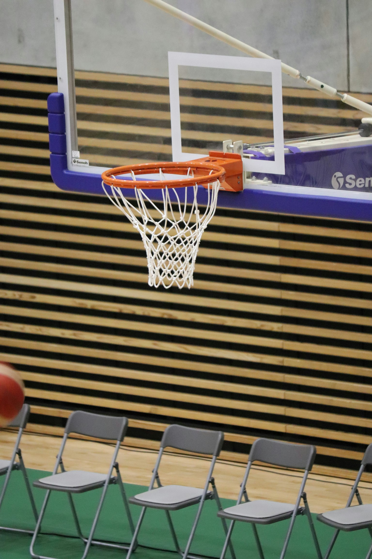 Ring basket di dalam gym dengan kursi yang disusun di dekatnya