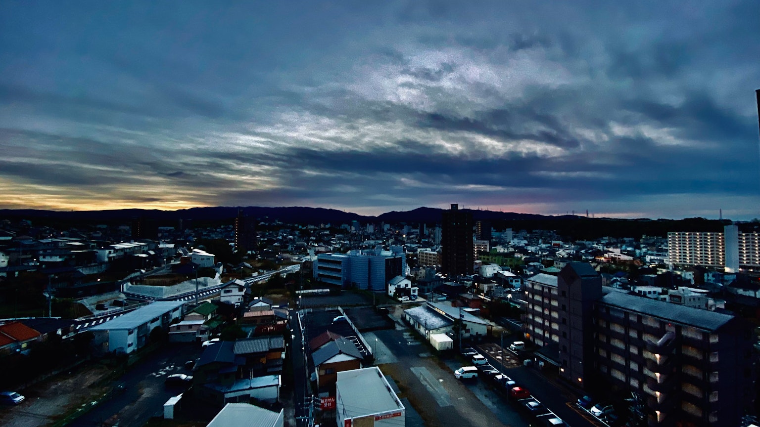 Paysage urbain au crépuscule avec des bâtiments hauts et un ciel nuageux