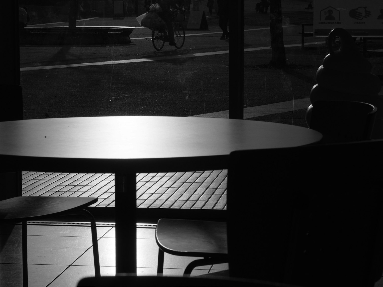 Silhouette de una mesa y sillas de café con vista de la escena exterior