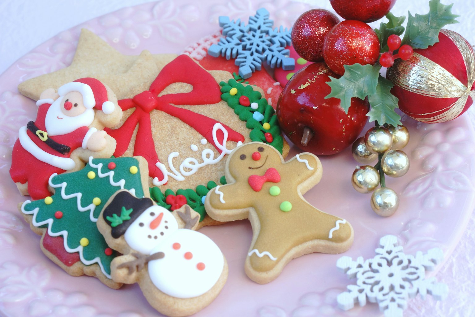 Piring dengan kue Natal yang didekorasi dan ornamen meriah