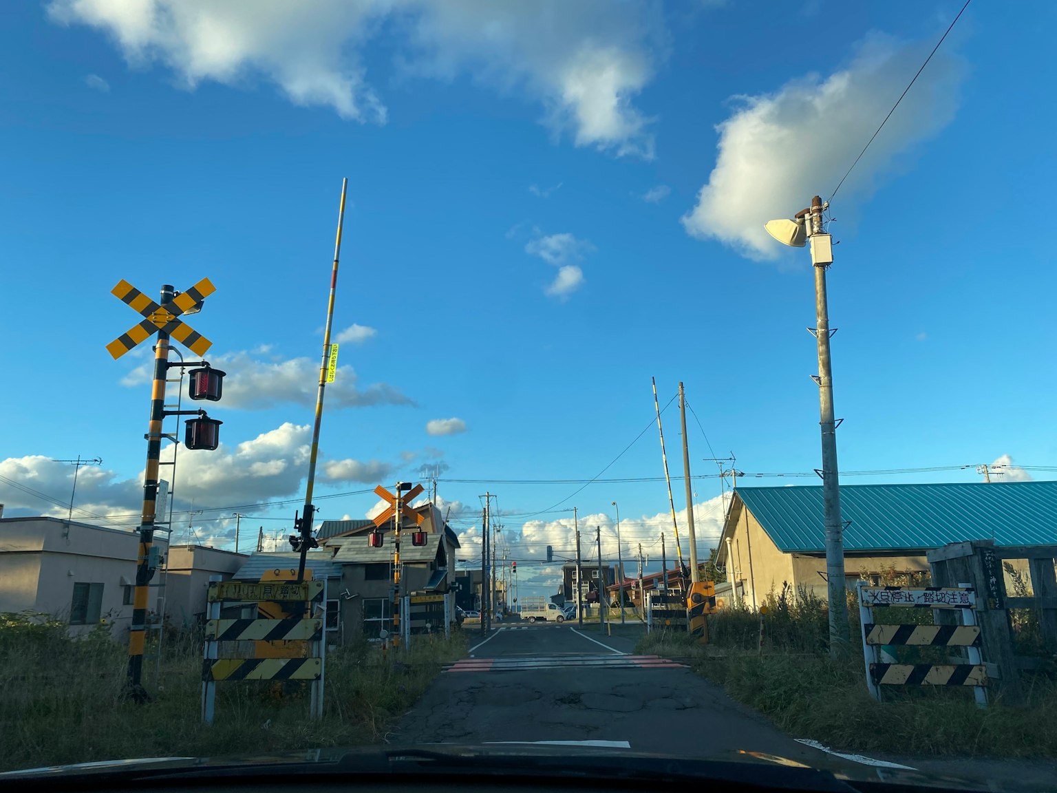 Railroad crossing and signals under a blue sky