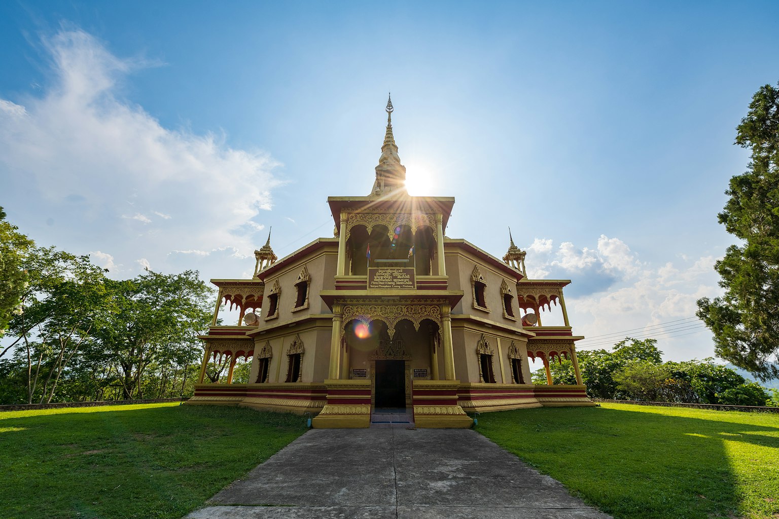 วัดทองที่สวยงามใต้ท้องฟ้าสีฟ้าล้อมรอบด้วยต้นไม้สีเขียว