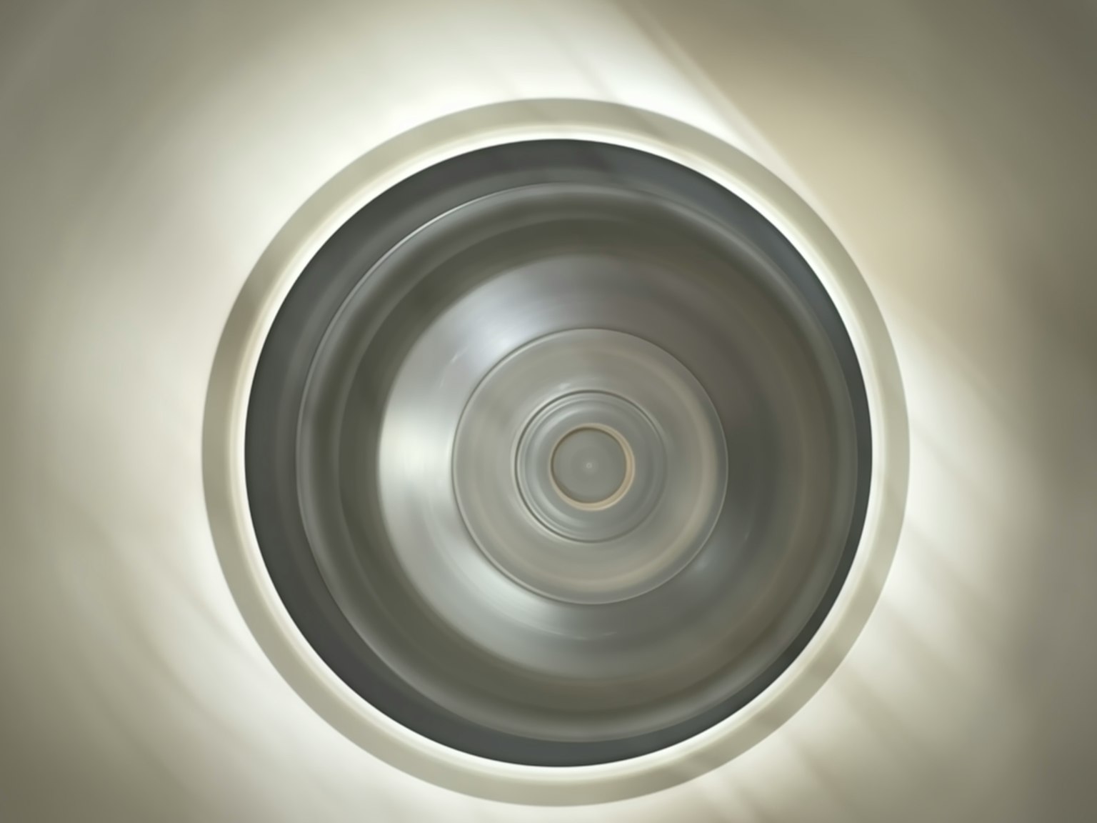 Vue d'un luminaire circulaire par en dessous avec une lumière douce rayonnant vers l'extérieur