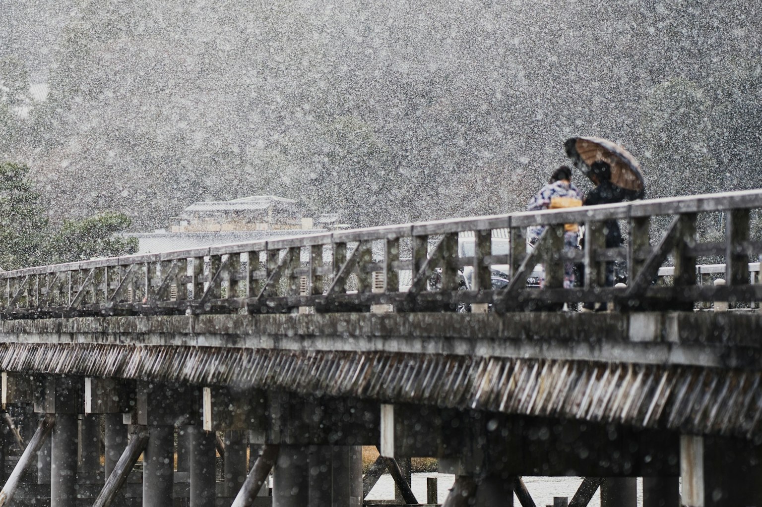 兩個人在雨中的橋上撐著傘