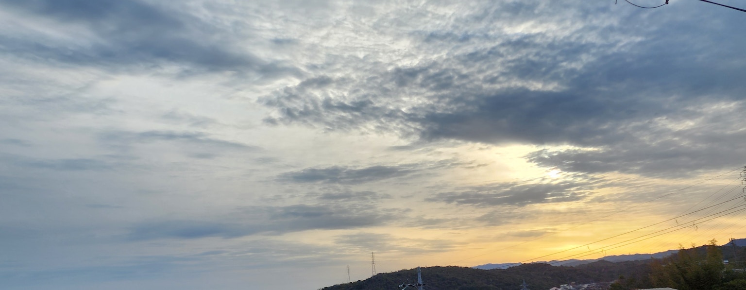 Una vista escénica de un cielo nublado con un sol poniente