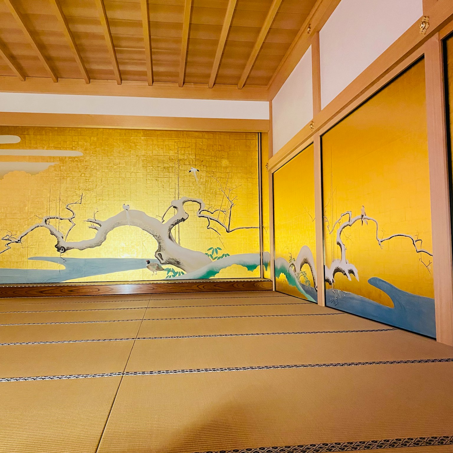 Interior de una habitación japonesa con pared dorada y tatami tradicional