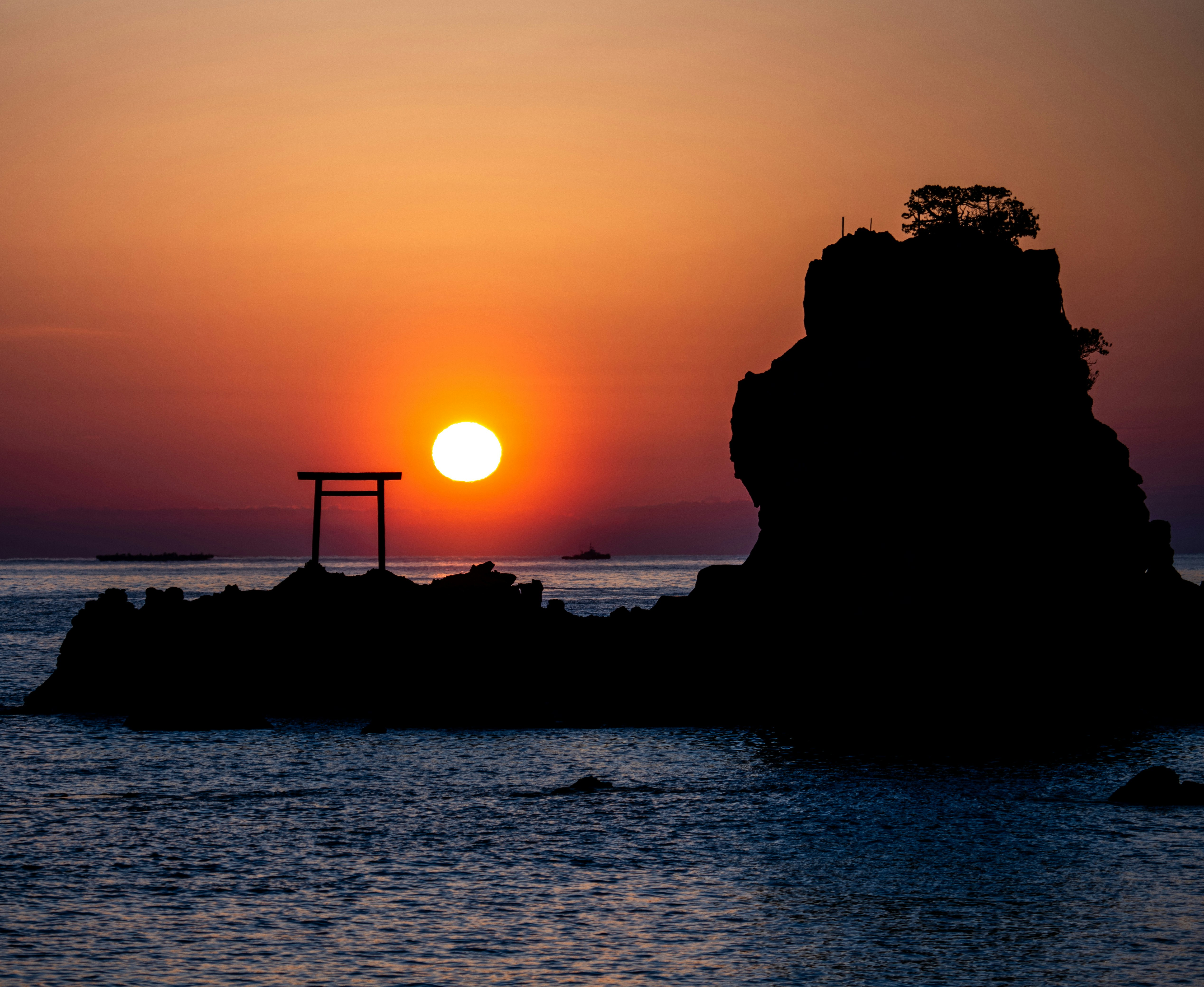 夕日に照らされた海と岩のある海岸の風景