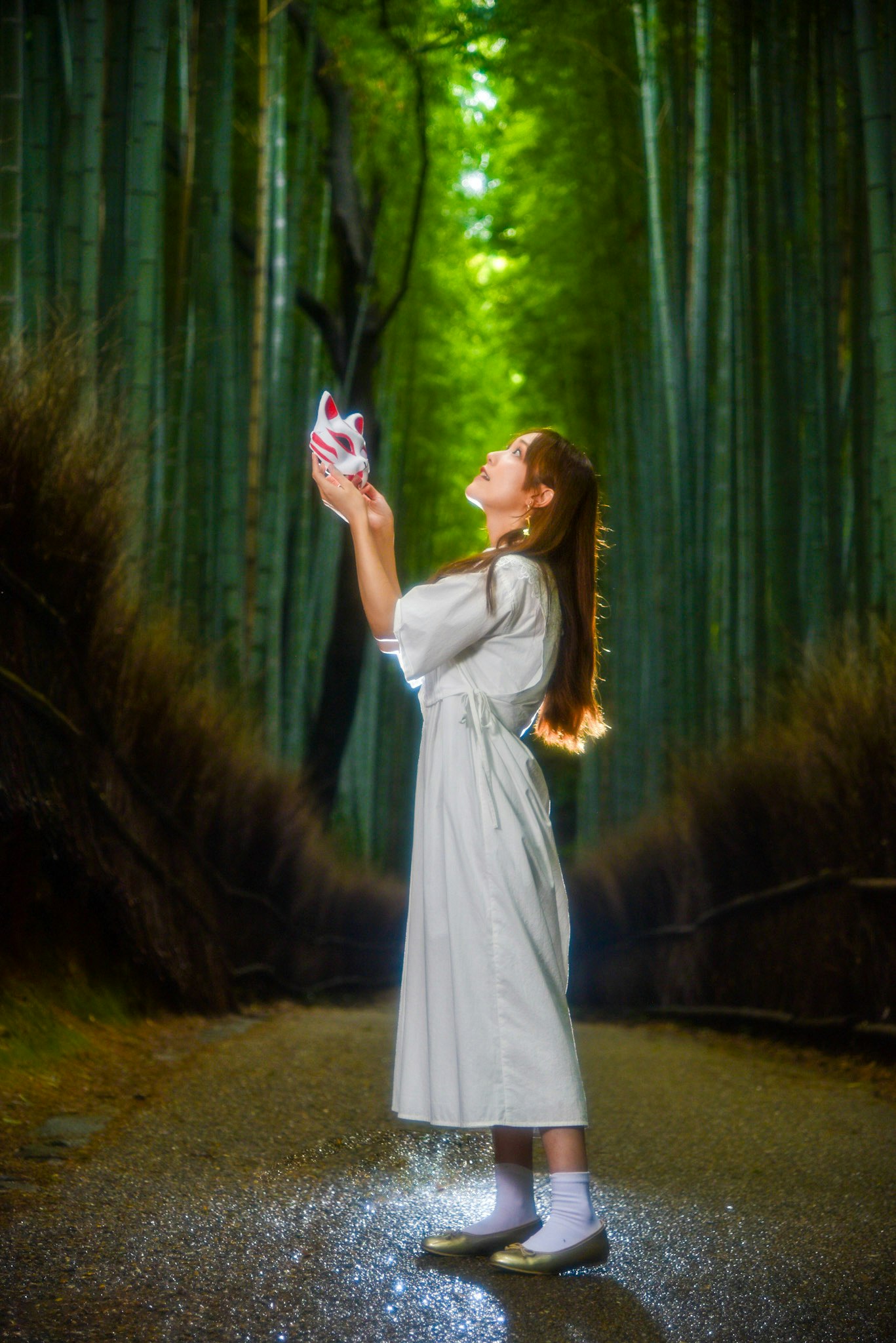 緑の竹林の中でカメラを持つ少女の姿