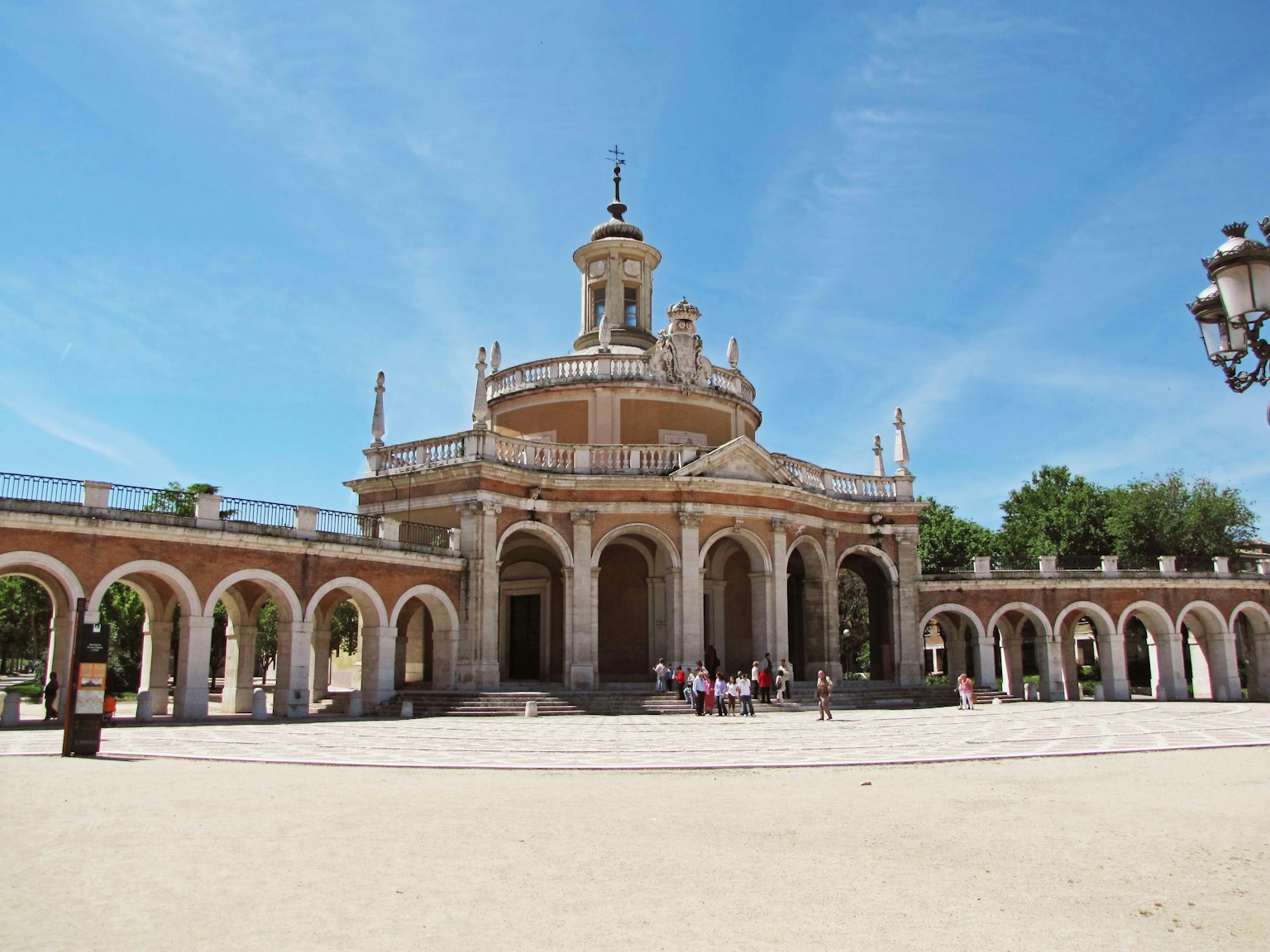 Un grande edificio con una cupola ornata sotto un cielo blu e una colonnata