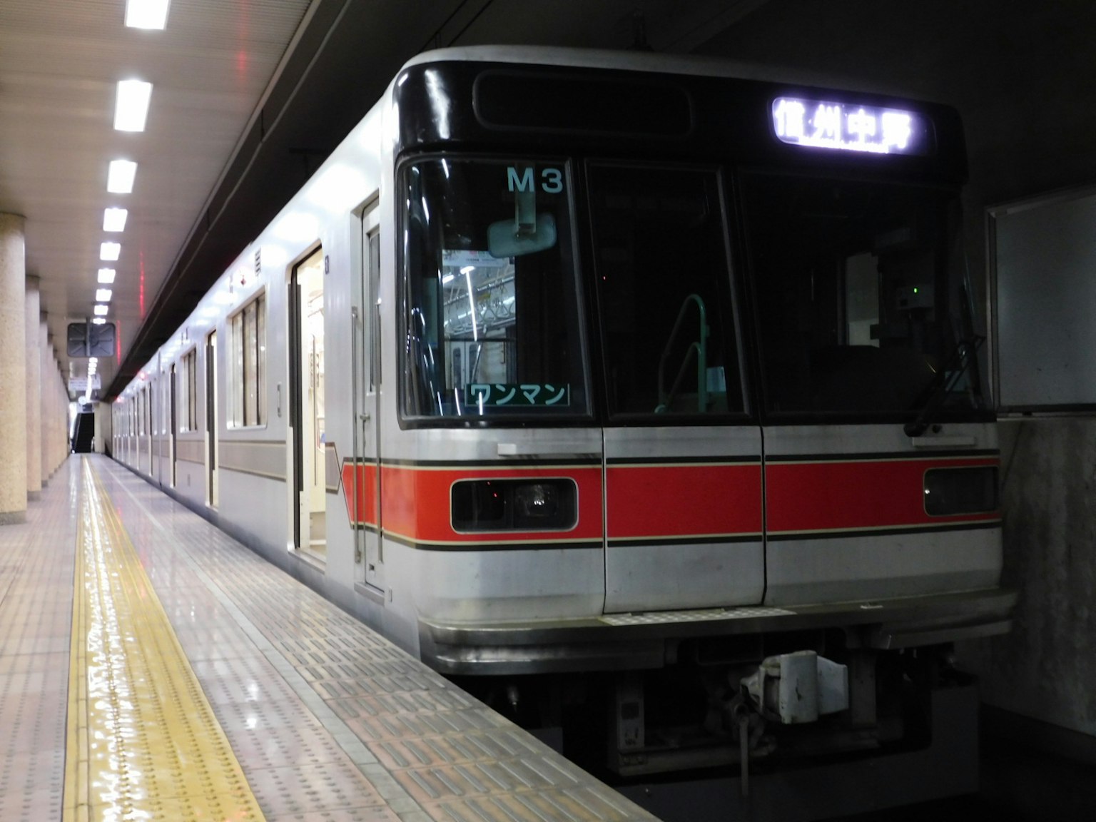 Treno fermo in una stazione della metropolitana corpo bianco con striscia rossa