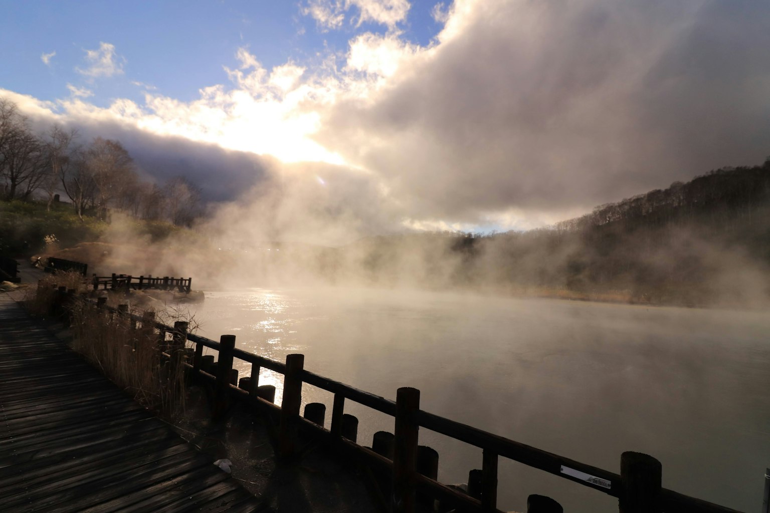 Vue pittoresque d'un lac brumeux avec un quai en bois