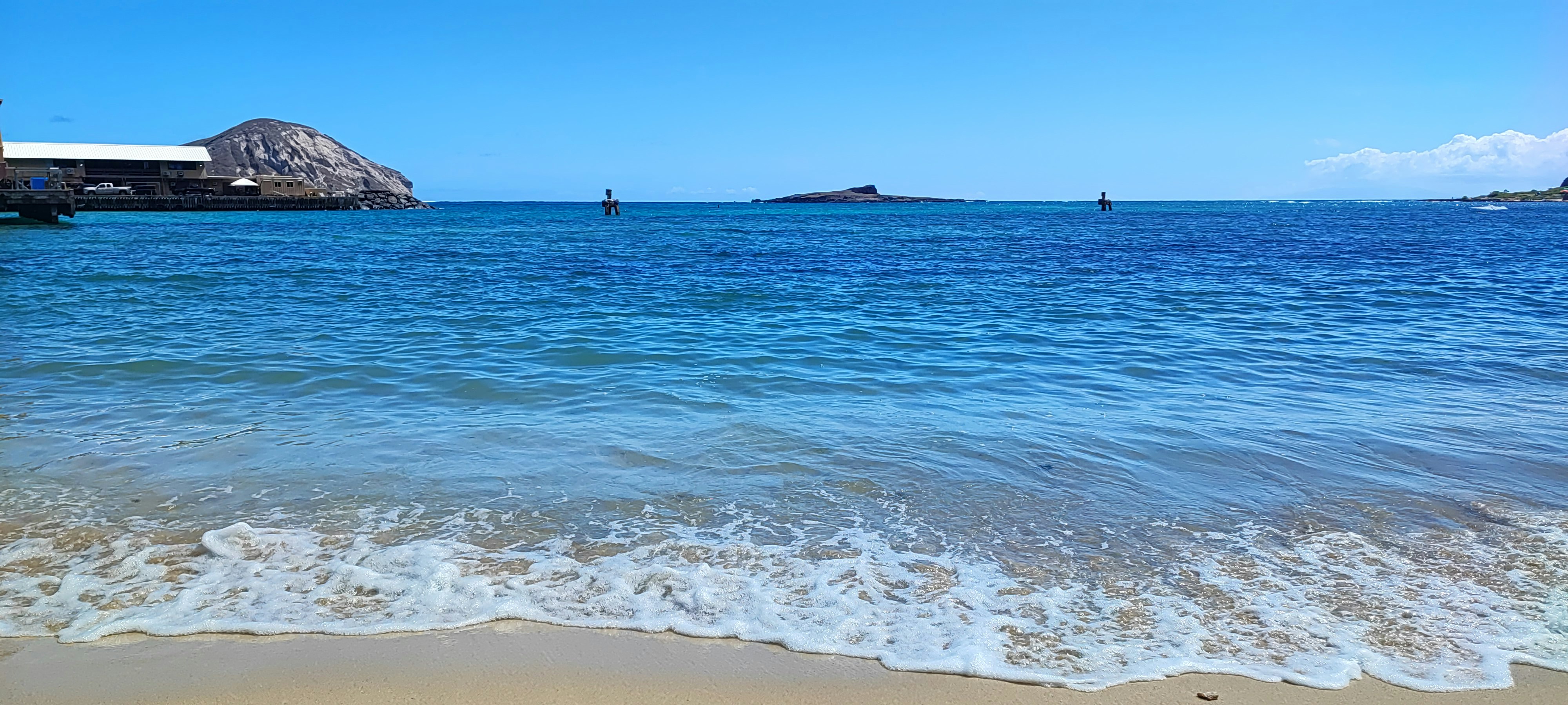 波打ち際と沖に浮かぶ海の風景