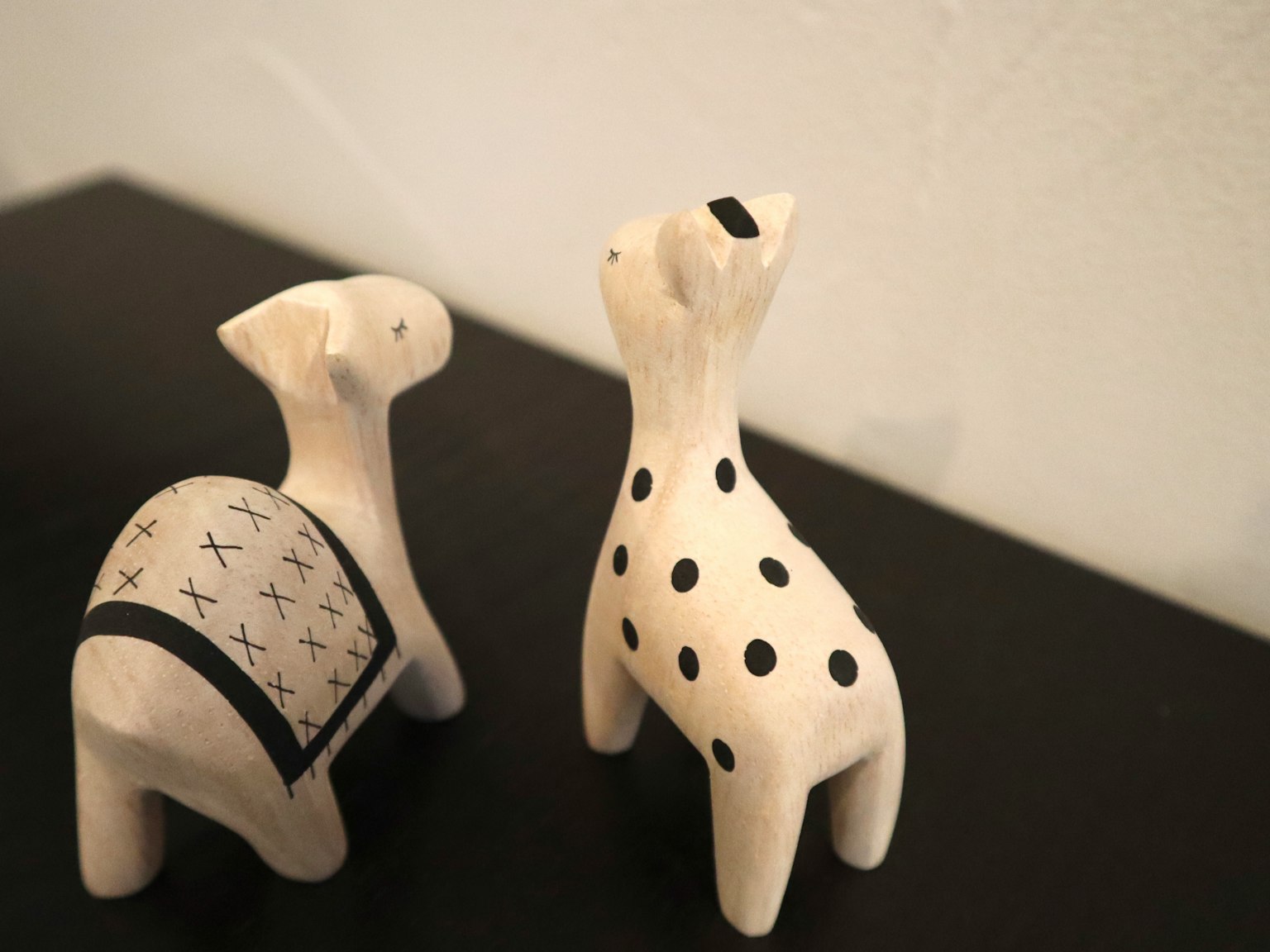 Deux sculptures animales en céramique avec des motifs noirs et blancs se faisant face