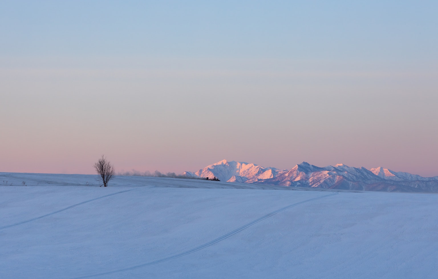 Paysage enneigé avec des montagnes au coucher du soleil en arrière-plan